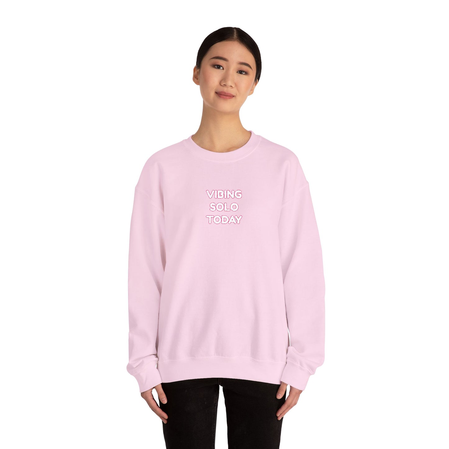Model in light pink crewneck, pink "VIBING SOLO TODAY" embroidery, chill black pants