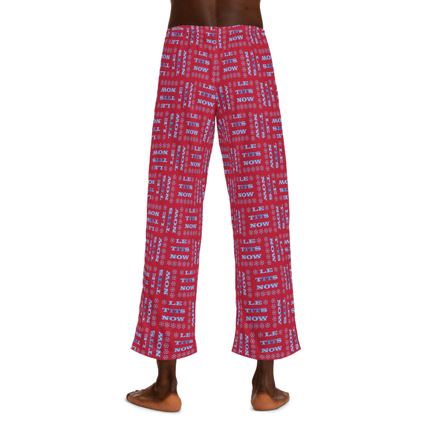 Back view of male model wearing red all-over "Le Tits Now" pun print pajama pants with snowflakes