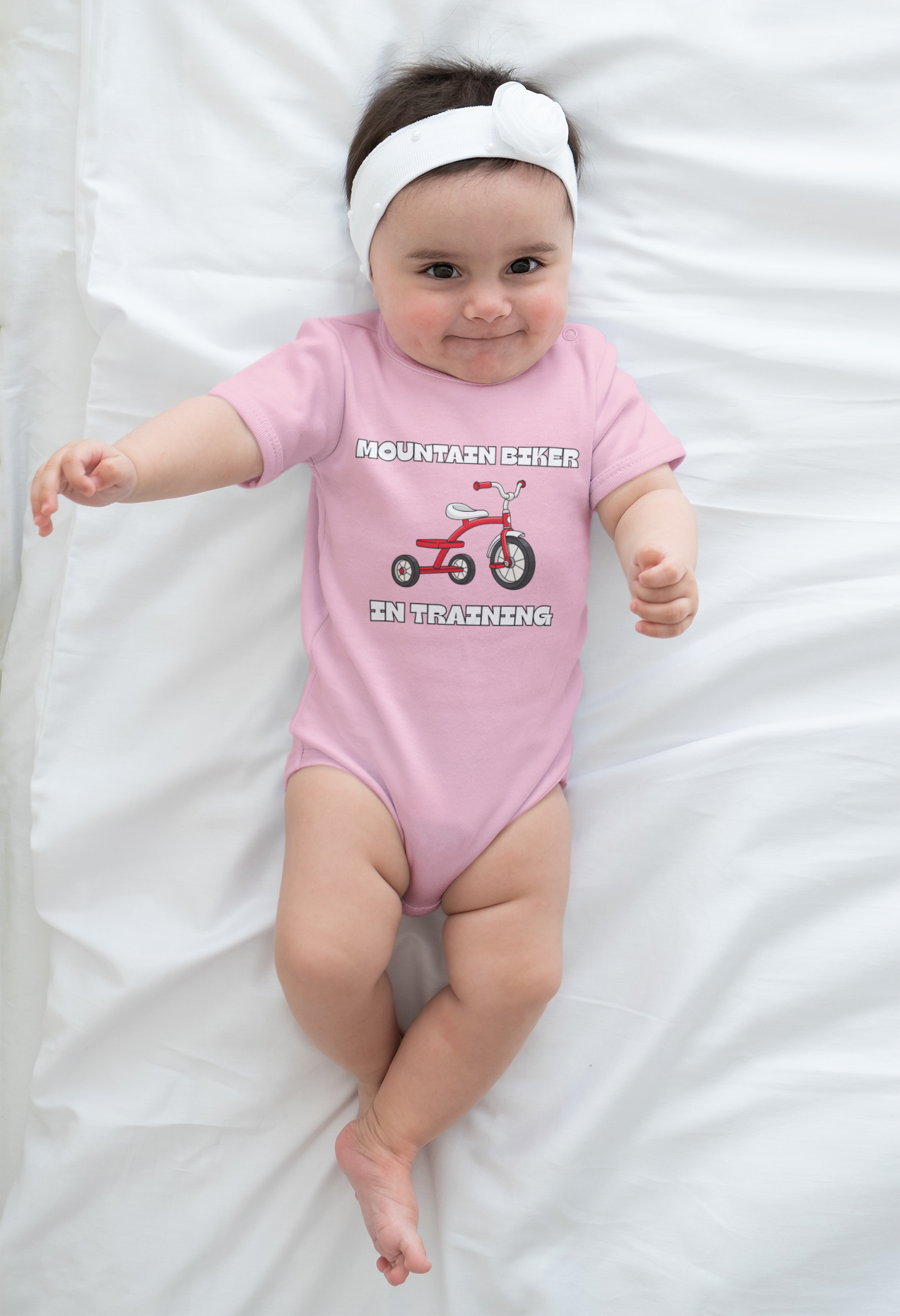 Baby girl in pink 'Mountain Biker in training' red tricycle infant tee - lying front view