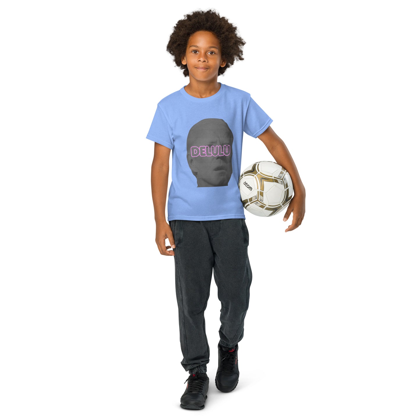 Front view of kid holding soccer ball in Carolina blue Delulu youth t-shirt, full gray face pink "DELU" design