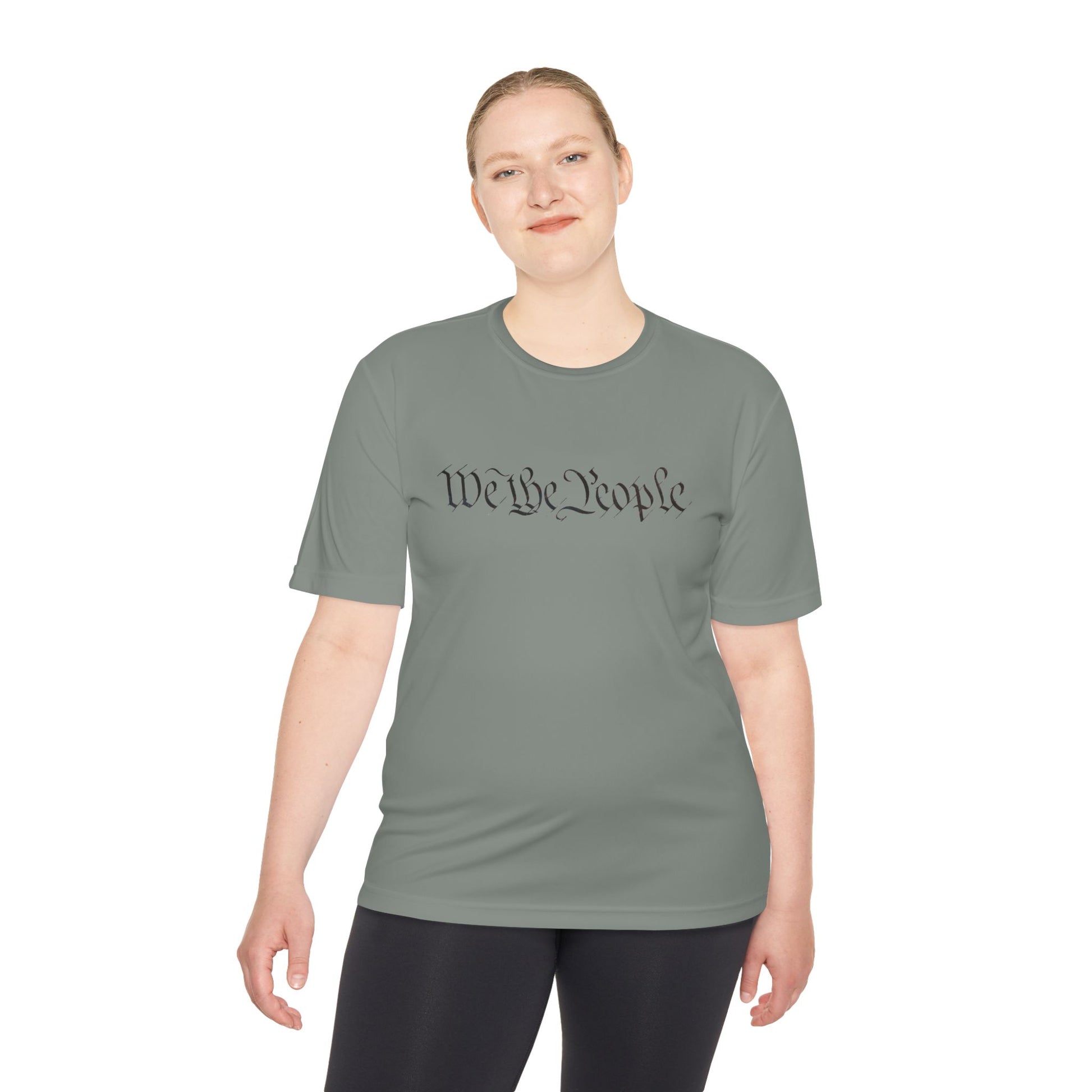 Female model in iron grey moisture-wicking tee featuring black cursive "We the People" print