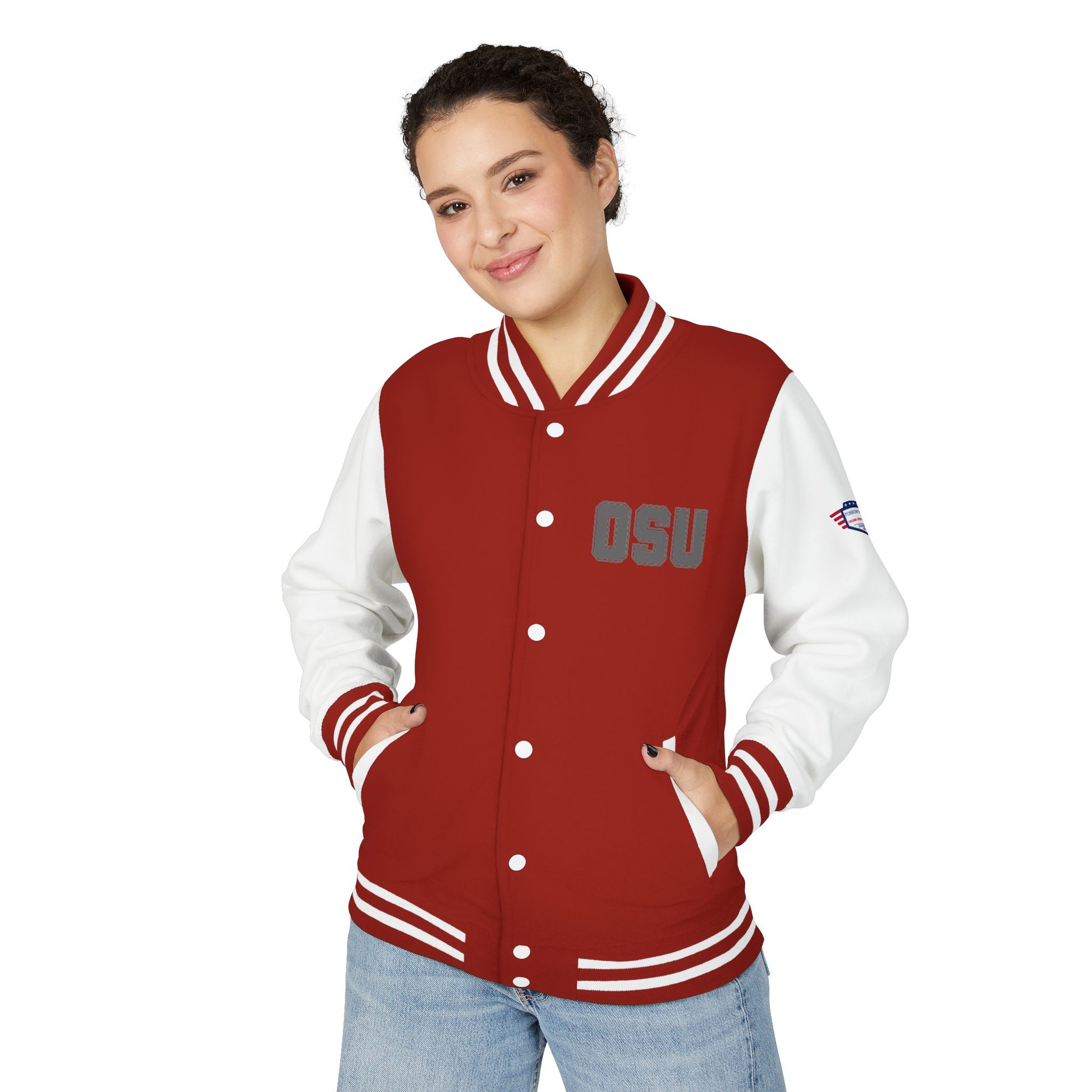 Woman model smiling in scarlet red OSU letterman jacket, hands in pockets over jeans, gray "OSU" chest embroidery, white sleeves pop