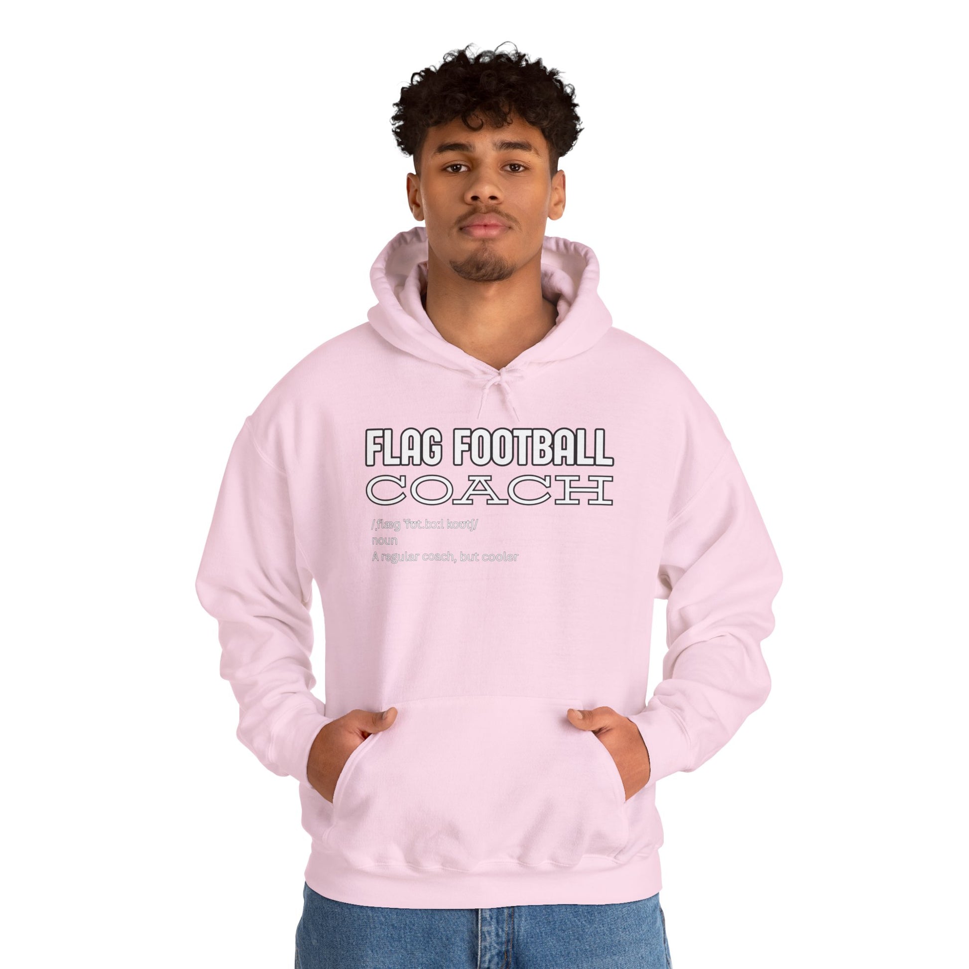 Curly-haired male model front view in light pink hoodie with "FLAG FOOTBALL COACH: A regular coach, but cooler" print