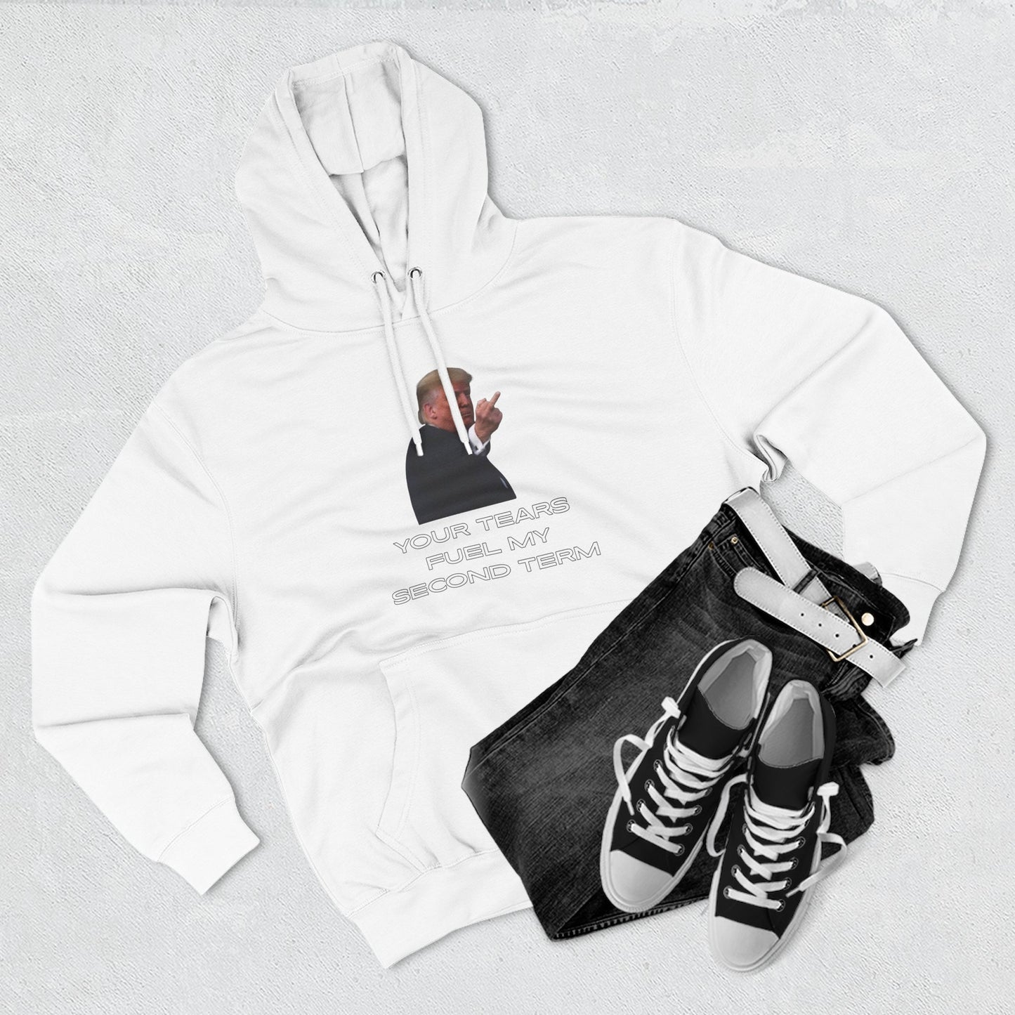 Flat lay of white Trump hoodie front print with jeans and black sneakers — rally ready