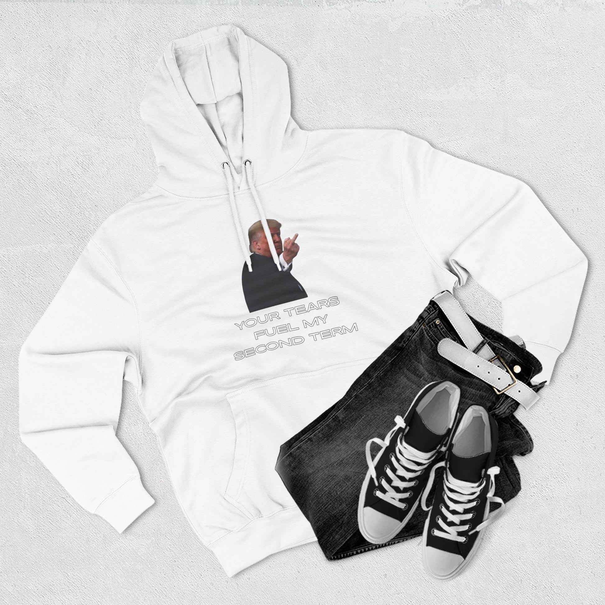 Flat lay of white Trump hoodie front print with jeans and black sneakers — rally ready