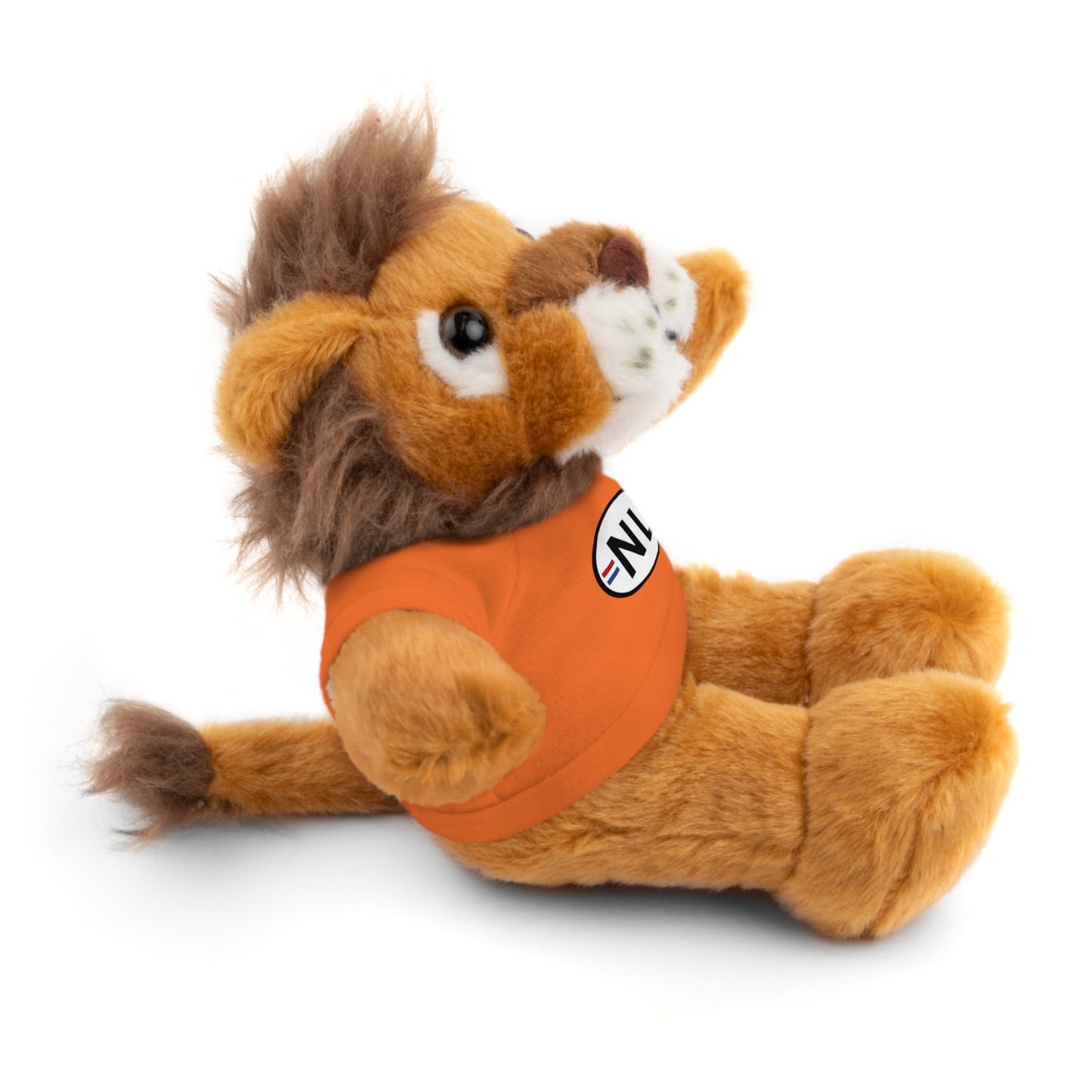 Side view of tan lion plush lying down, brown mane flowing, orange t-shirt showing =NL= badge detail