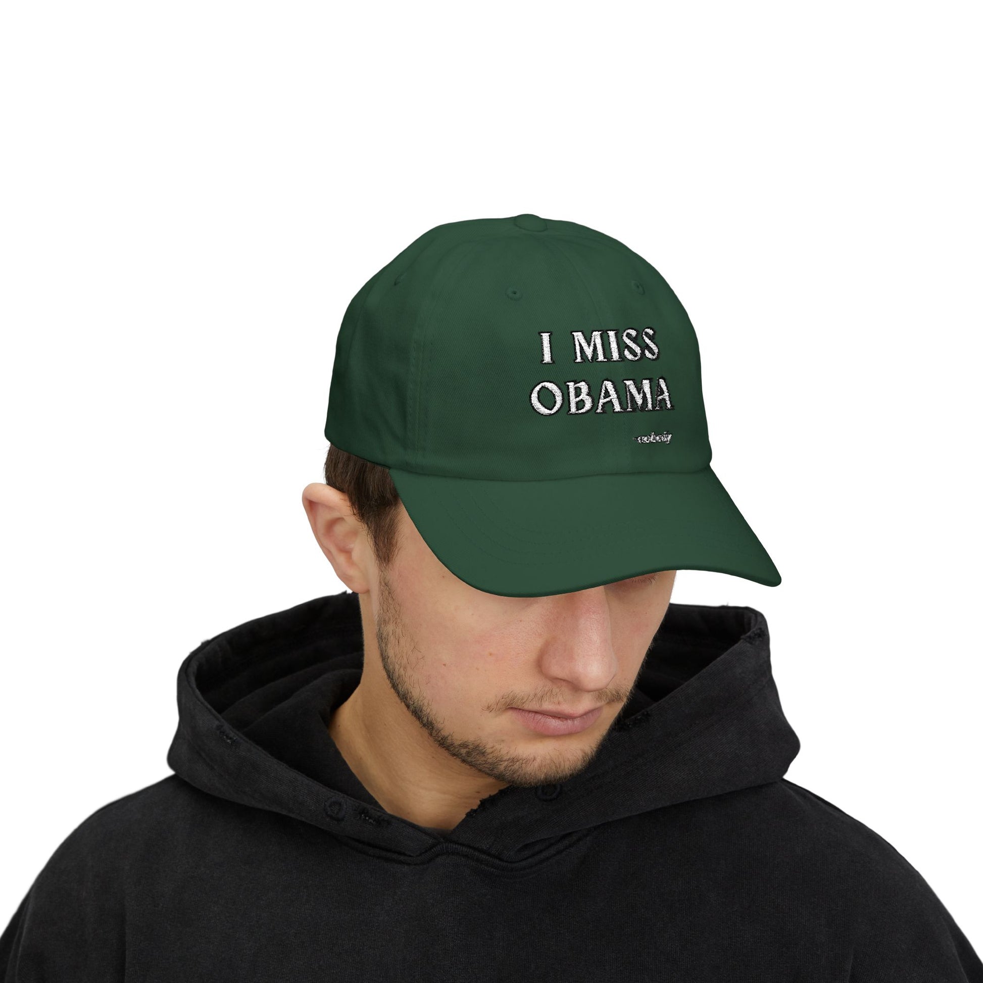 Man model in black hoodie wearing spruce green "I MISS OBAMA -nobody" embroidered dad hat front view