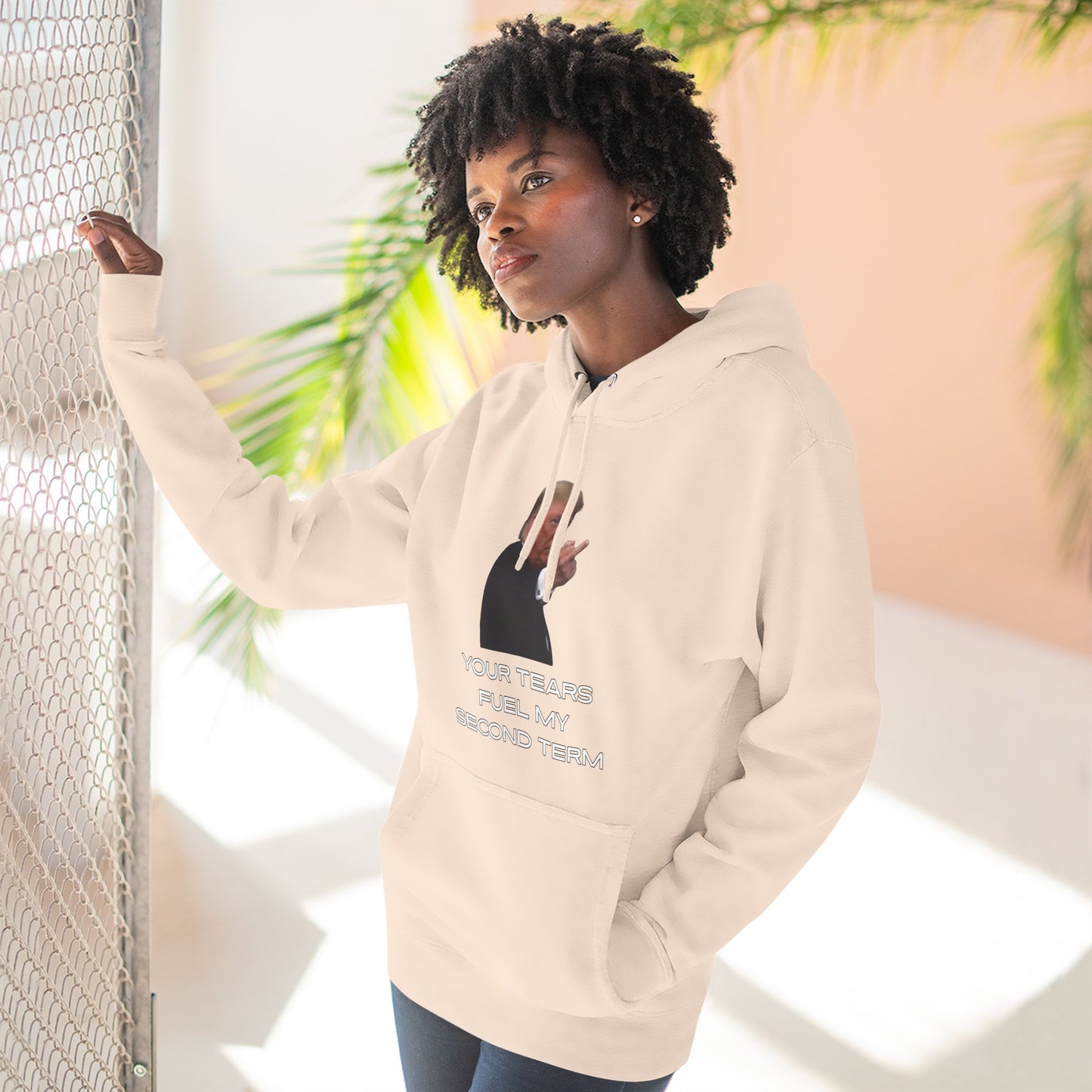 Curly-haired woman posing in heather gray hoodie, front Trump plant flip-off print and text