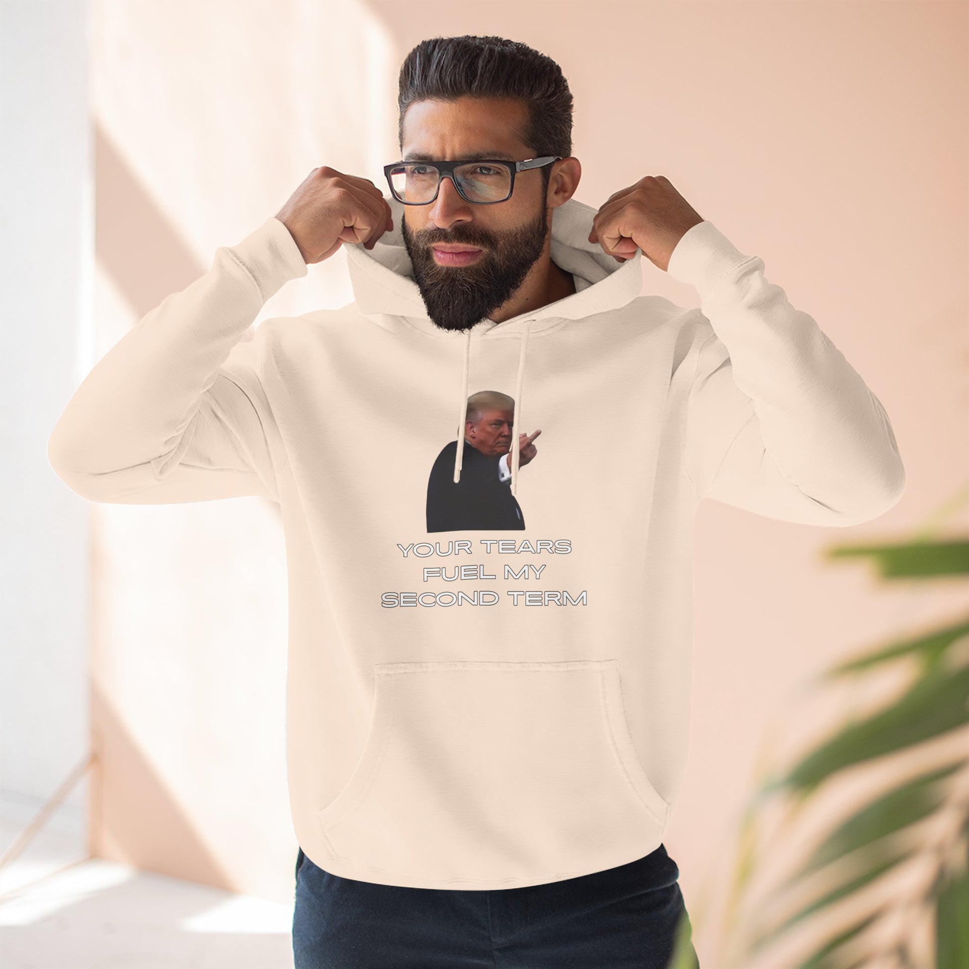 Bearded guy flexing in heather gray hoodie, Trump middle finger graphic and "YOUR TEARS FUEL MY SECOND TERM"