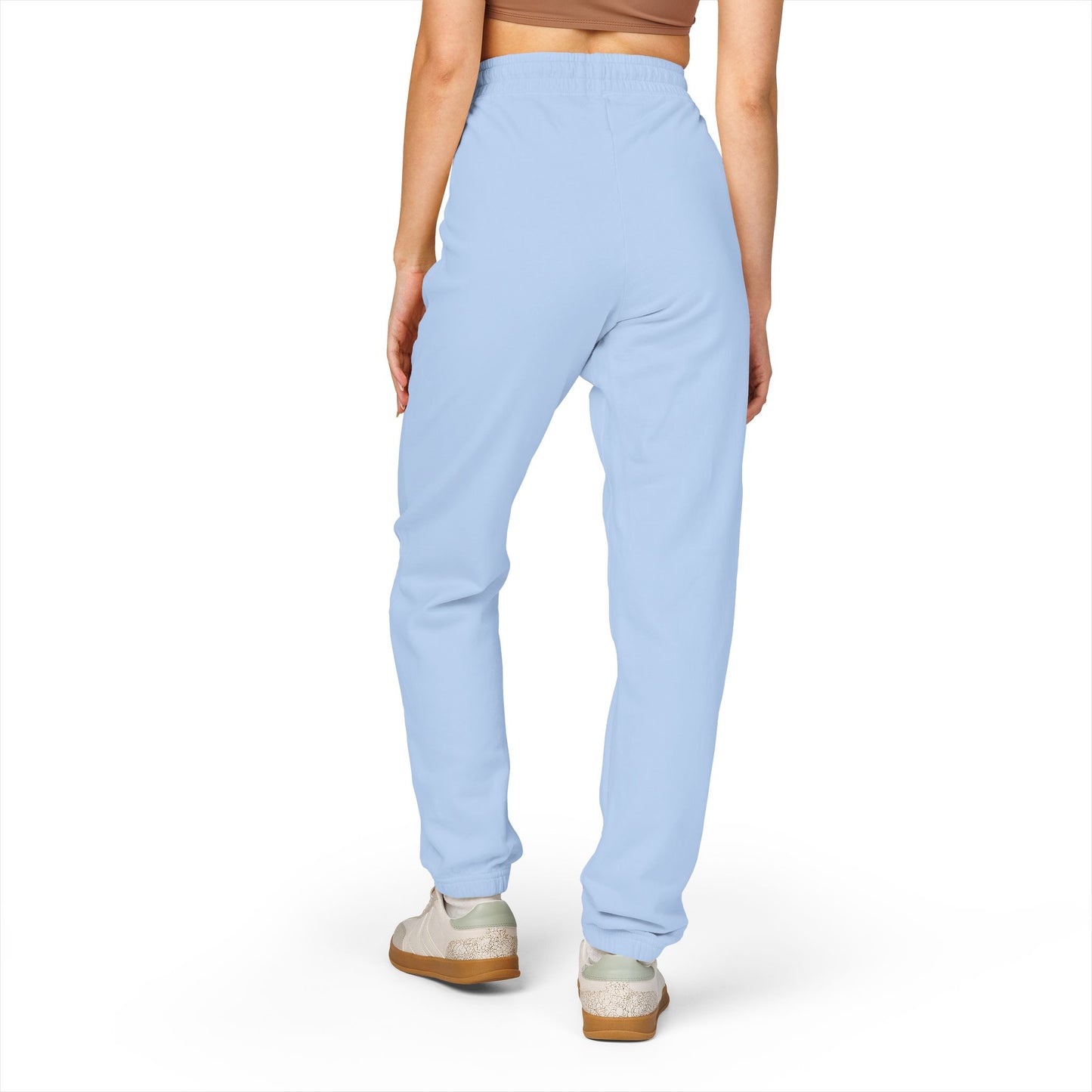 Back view of model lounging in light blue Zeta fleece sweatpants, crop top & white sneakers