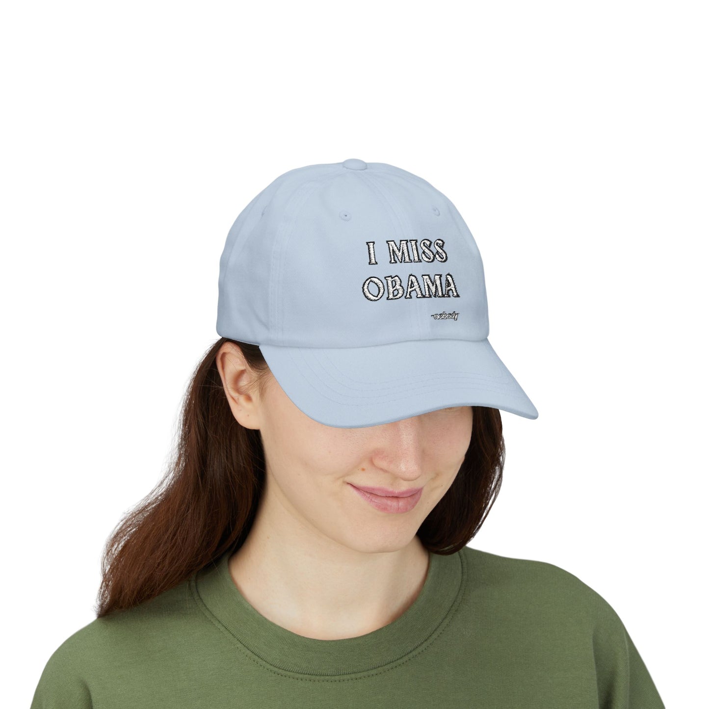 Smiling woman in green top with light blue "I MISS OBAMA -nobody" dad hat, front lifestyle view