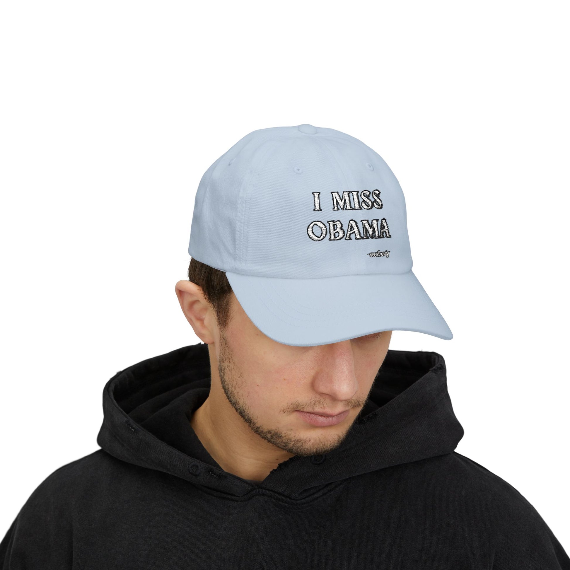 Man model in black hoodie sporting light blue "I MISS OBAMA -nobody" embroidered dad hat upfront