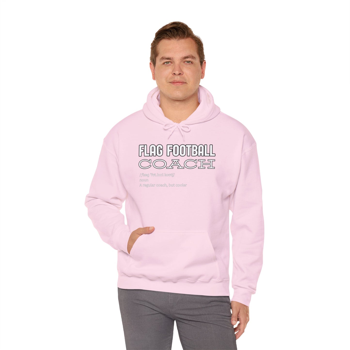 Male model owning light pink "Flag Football Coach (flag foot coach)" hoodie, front view with hands in pockets