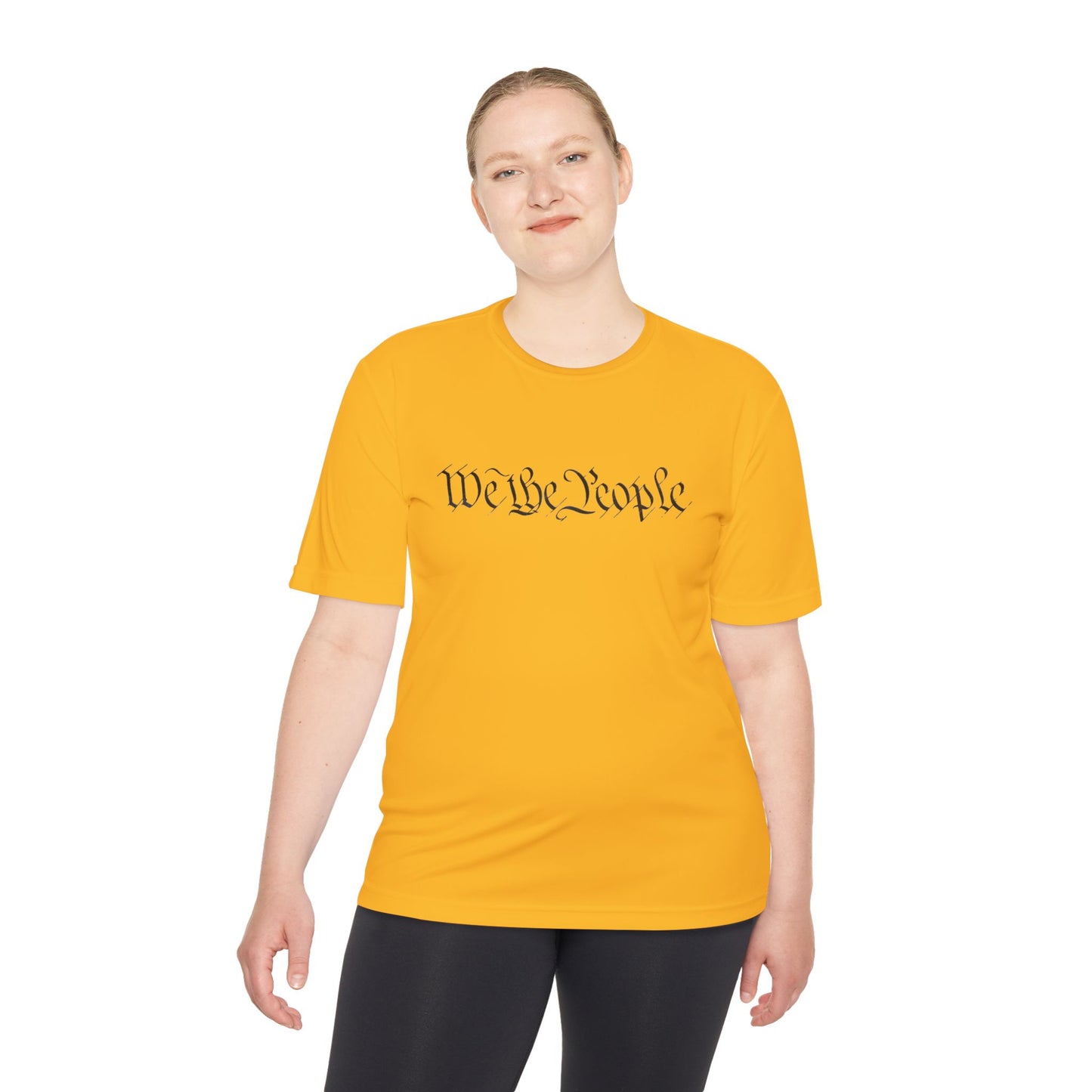 Female model in yellow moisture-wicking tee, grinning at "We the People" front print
