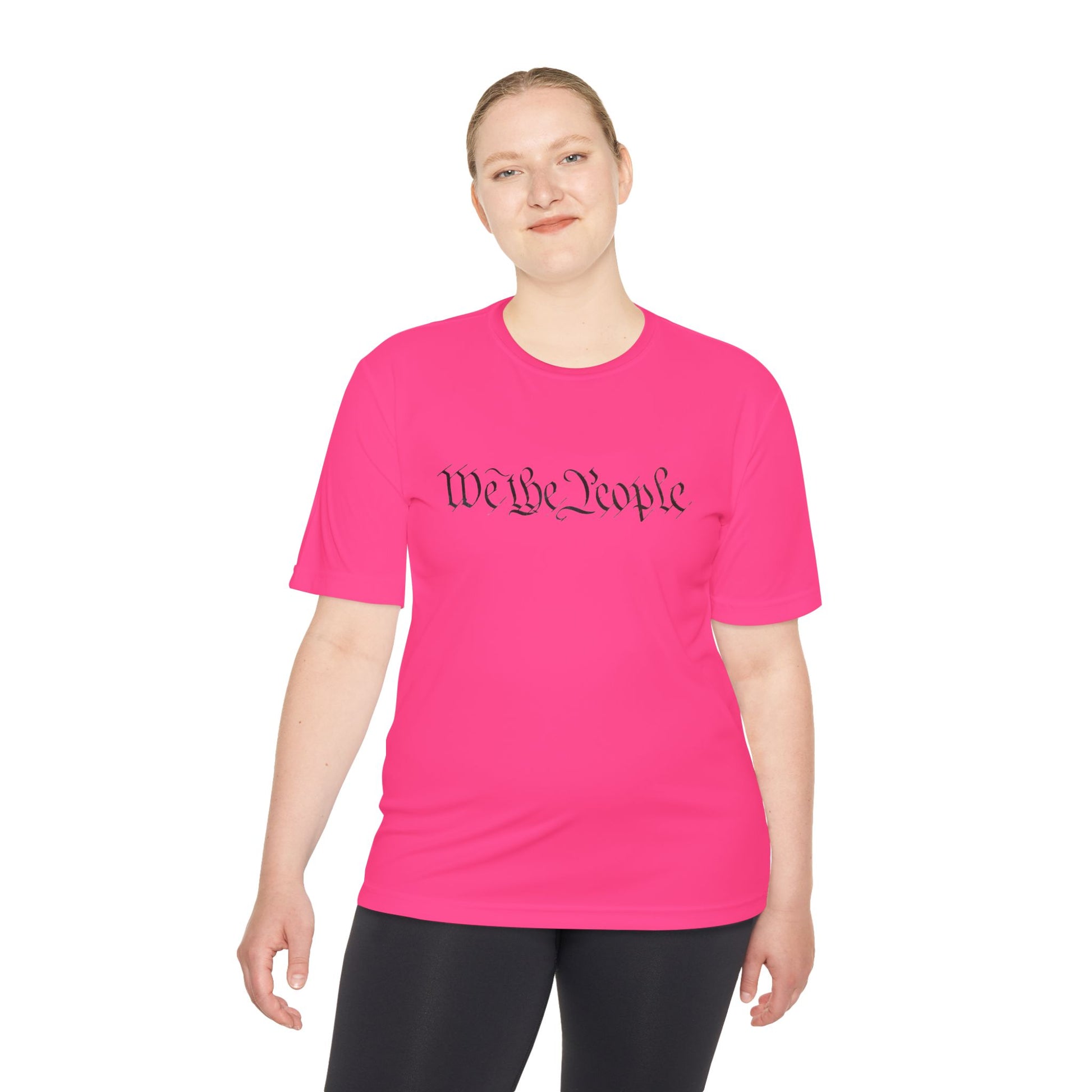 Female model front view smiling in hot pink athletic tee, black cursive "We the People" print