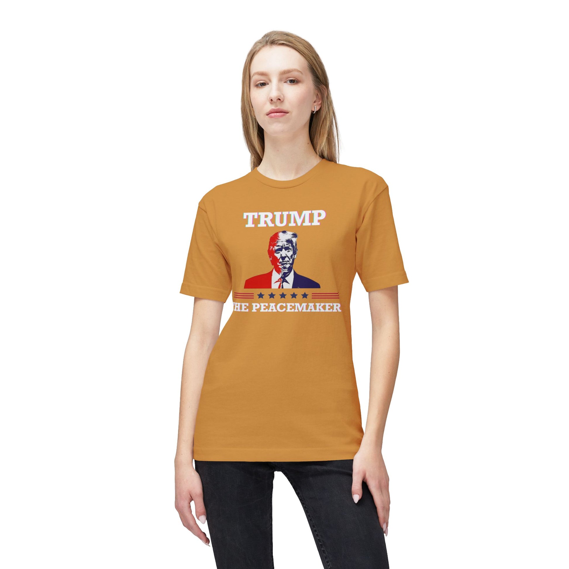 Blonde model rocks front view of orange tee with "TRUMP", Trump portrait, "HE ★ PEACEMAKER" — peacemaker glow-up