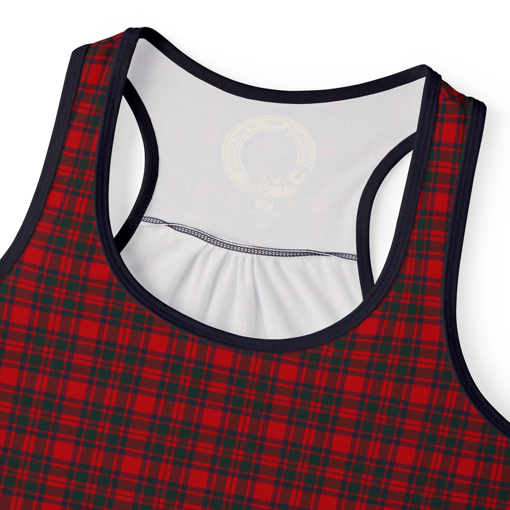 Close-up of racerback neckline on red-black plaid tank, showing white interior, gold circular crest, and navy straps