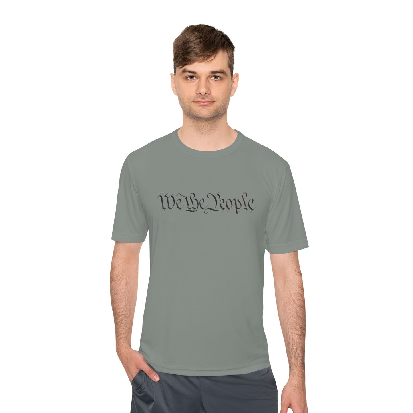Male model owning the iron grey "We the People" moisture-wicking tee, hands in pockets