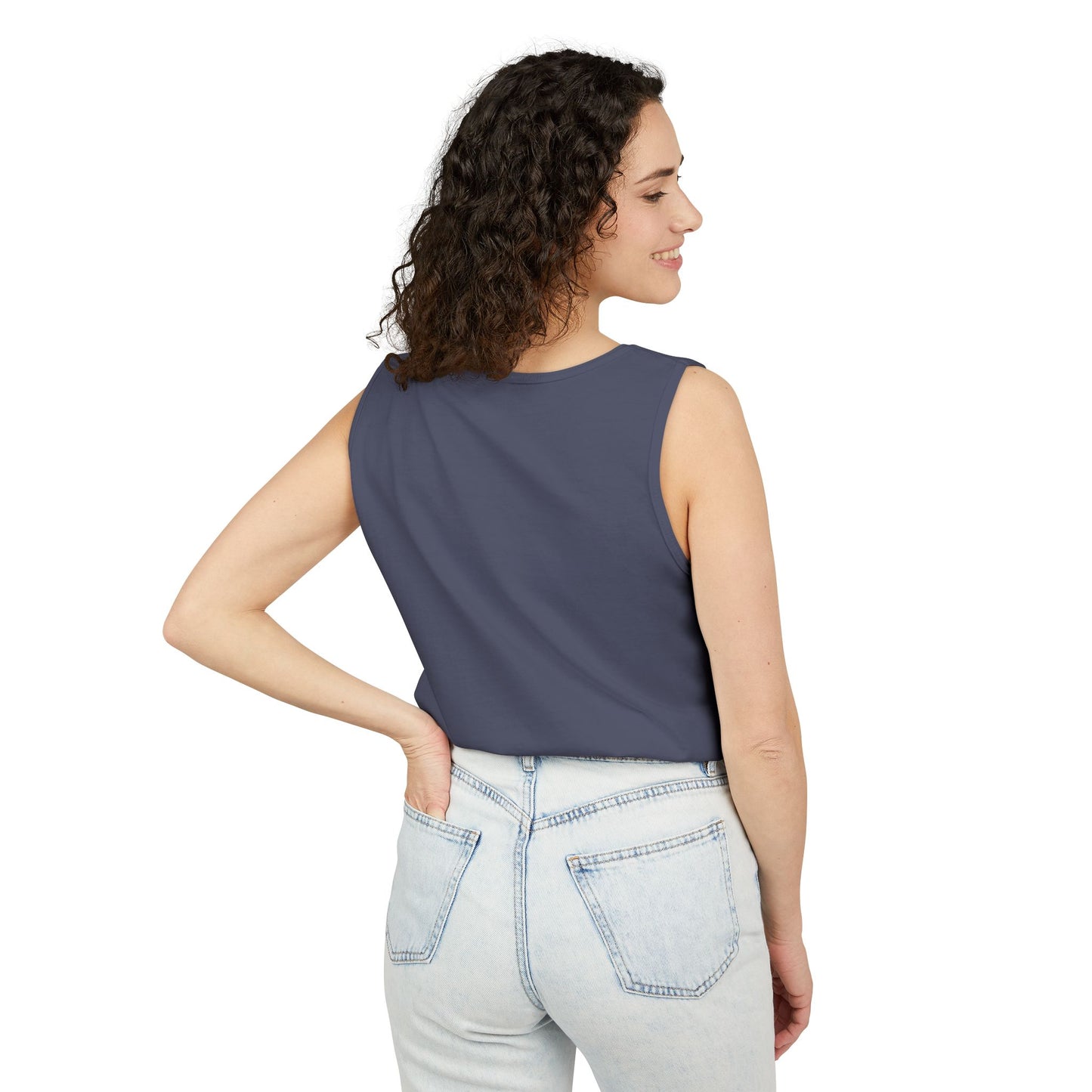 Side view of woman in plain navy tank top, hands on hips in light-wash jeans