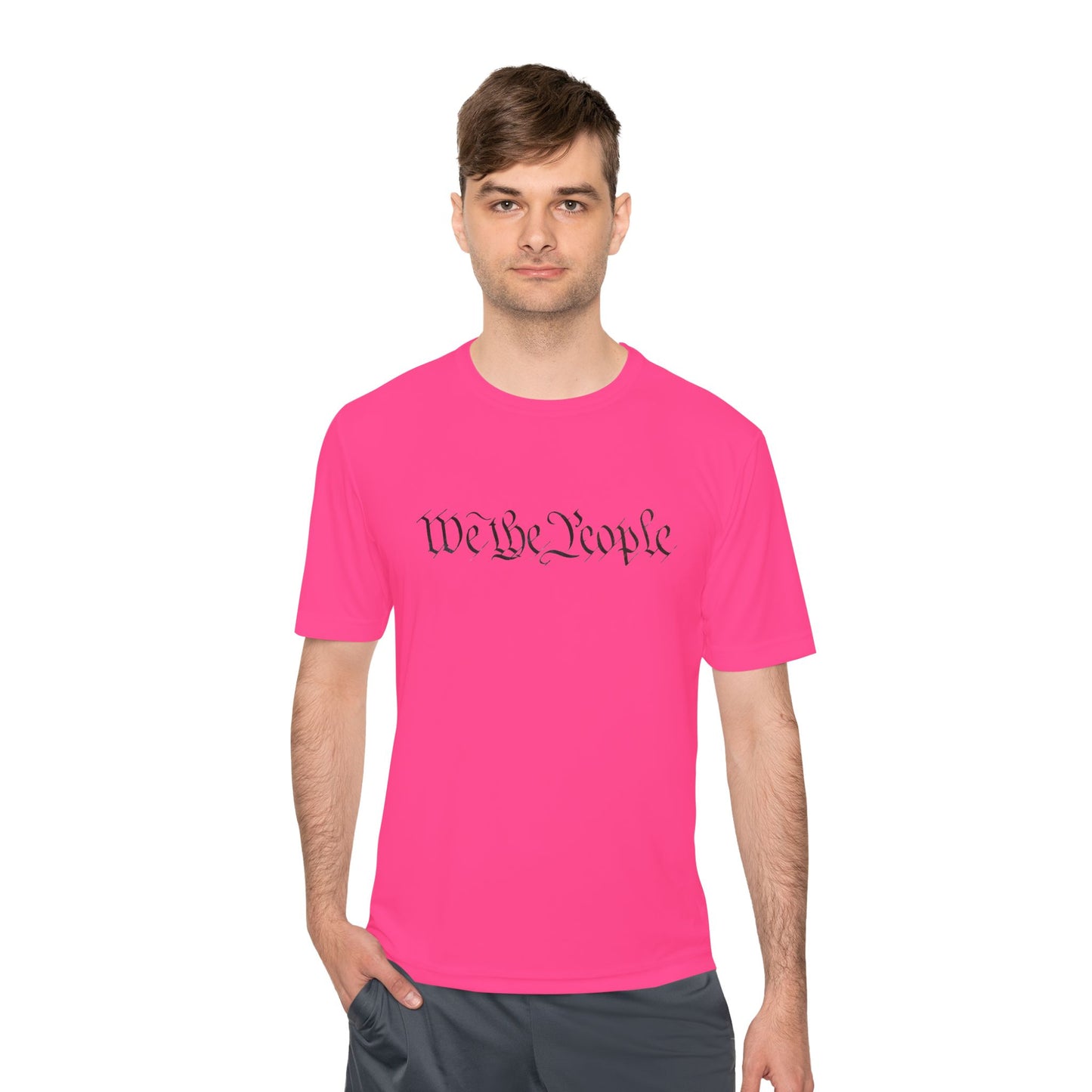 Male model front view in hot pink moisture-wicking tee with black cursive "We the People" script across chest