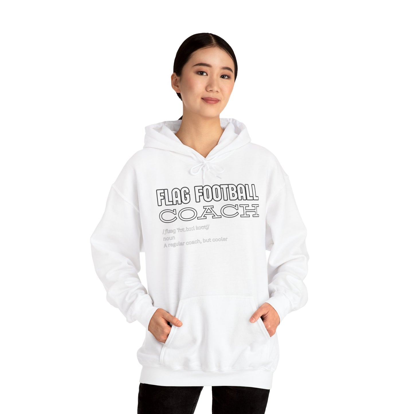 Asian woman in white Flag Football Coach hoodie, front view with hands in pockets, smirking confidently
