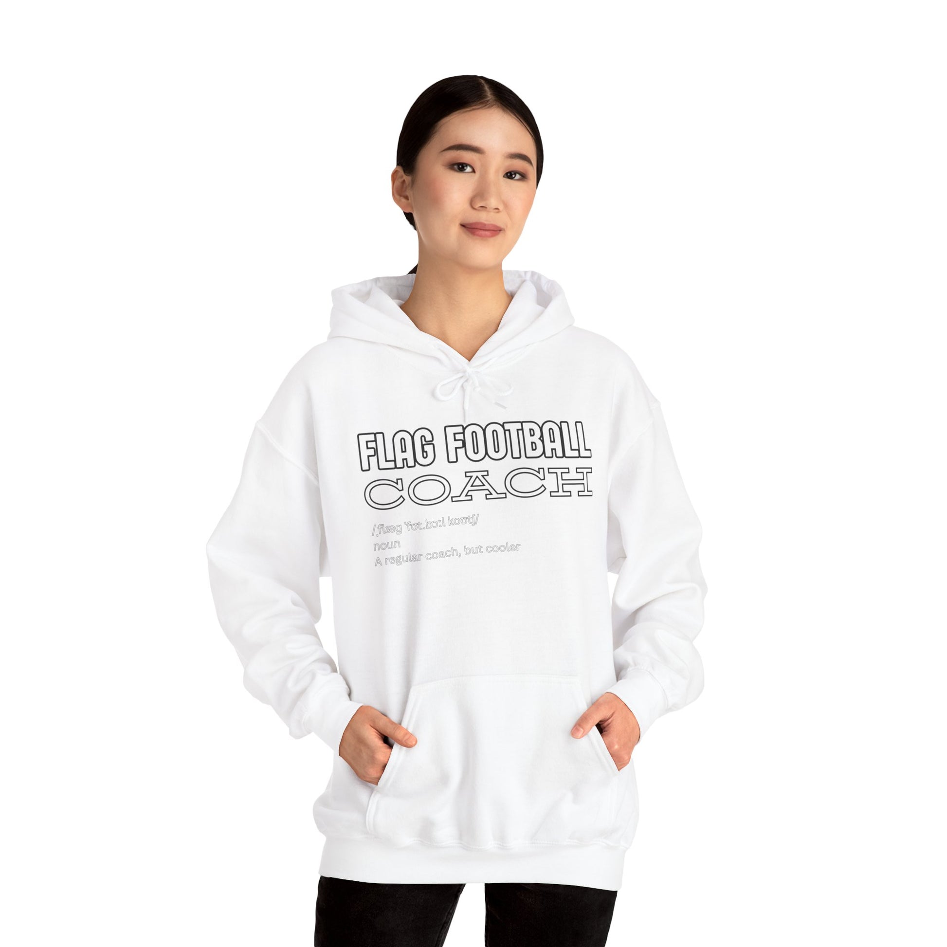Asian woman in white Flag Football Coach hoodie, front view with hands in pockets, smirking confidently