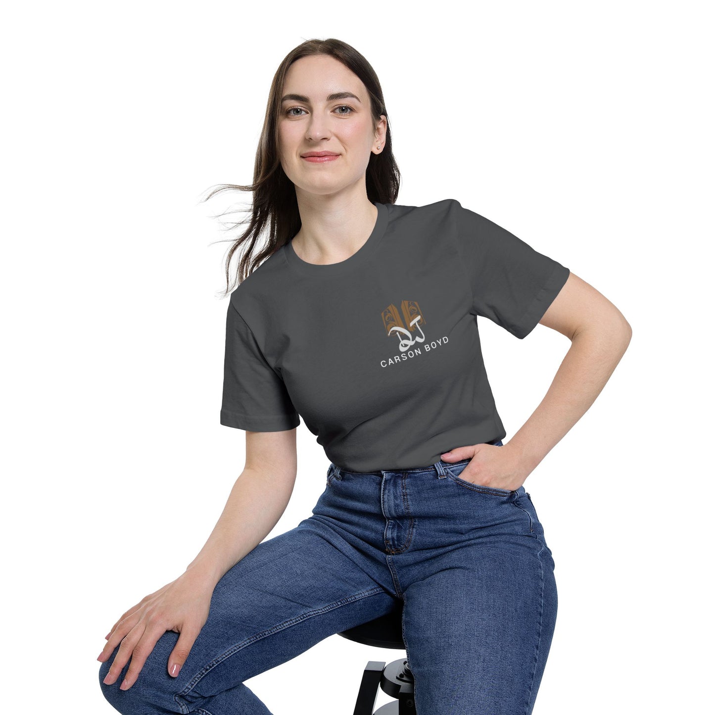 Female model seated smirking in heather gray short sleeve, artful tan DJ Carson Boyd emblem on chest