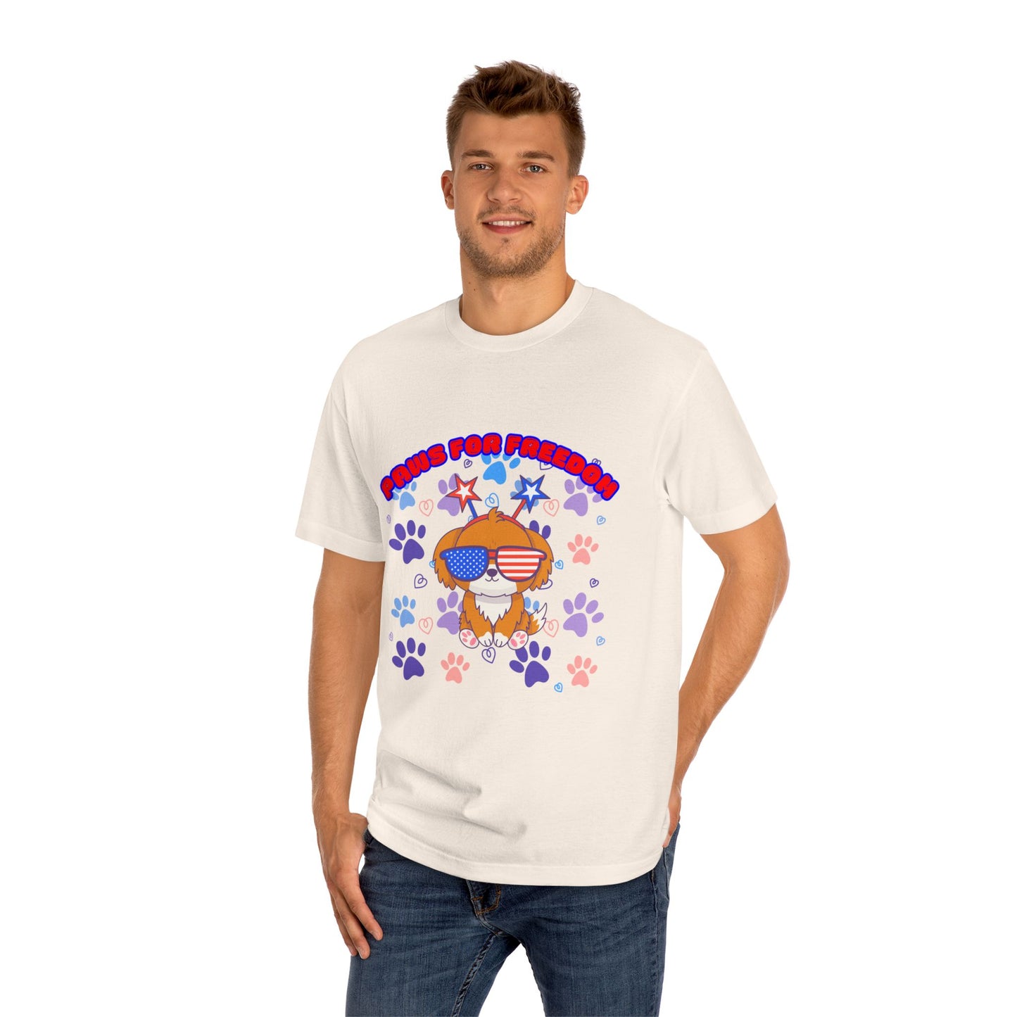 Male model in white 'Paws for Freedom' tee, front view: orange dog with shades & flag bandana amid colorful paws & stars