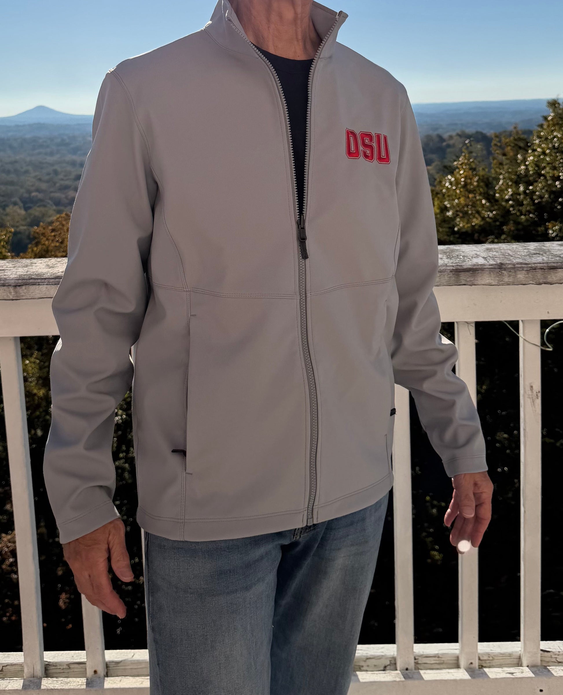 Older dude in light grey zipped OSU jacket, front view outdoors with epic mountain vista and crisp fall vibes