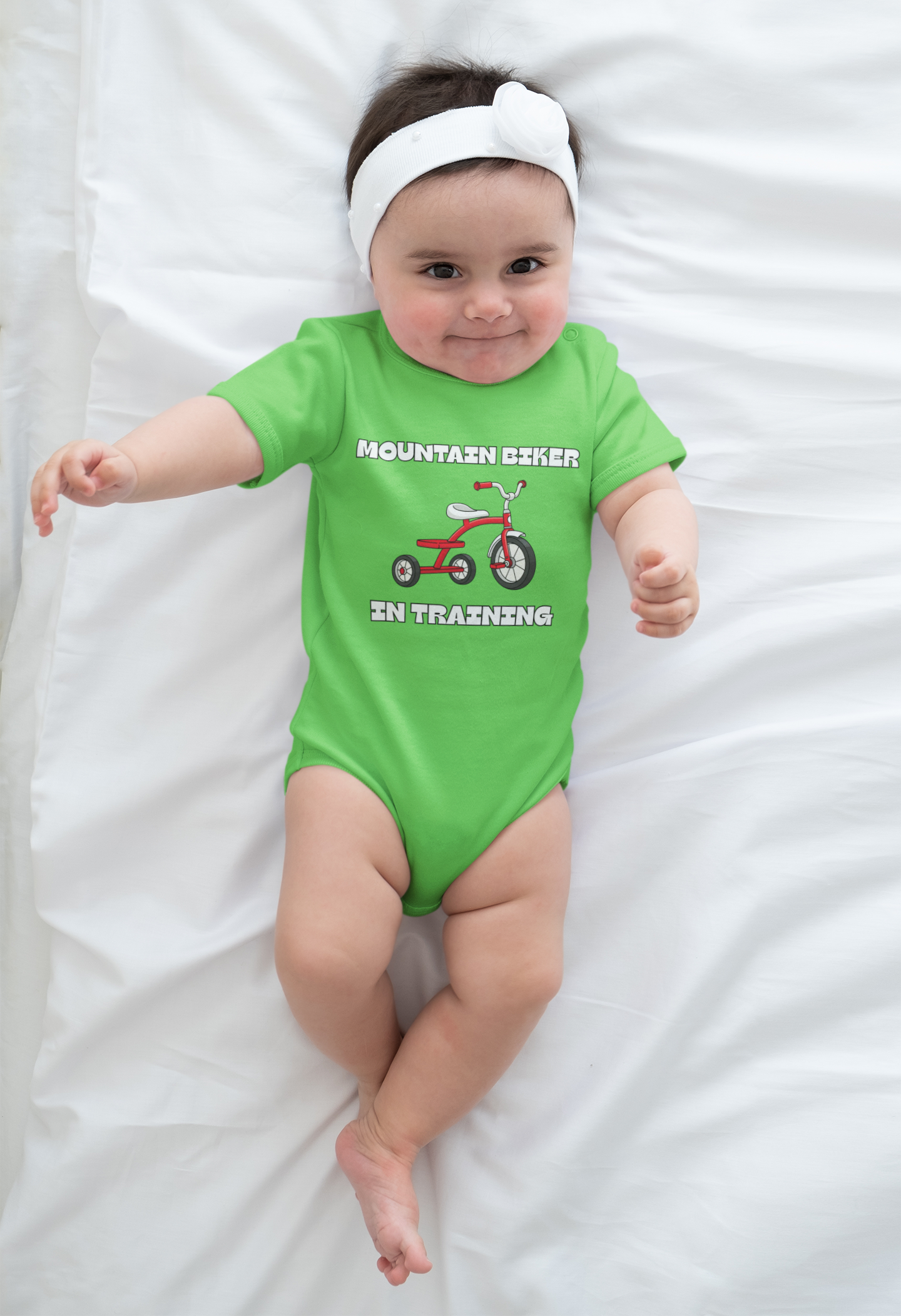 Toddler boy in light blue 'Mountain Biker in training' tee with red tricycle - outdoor