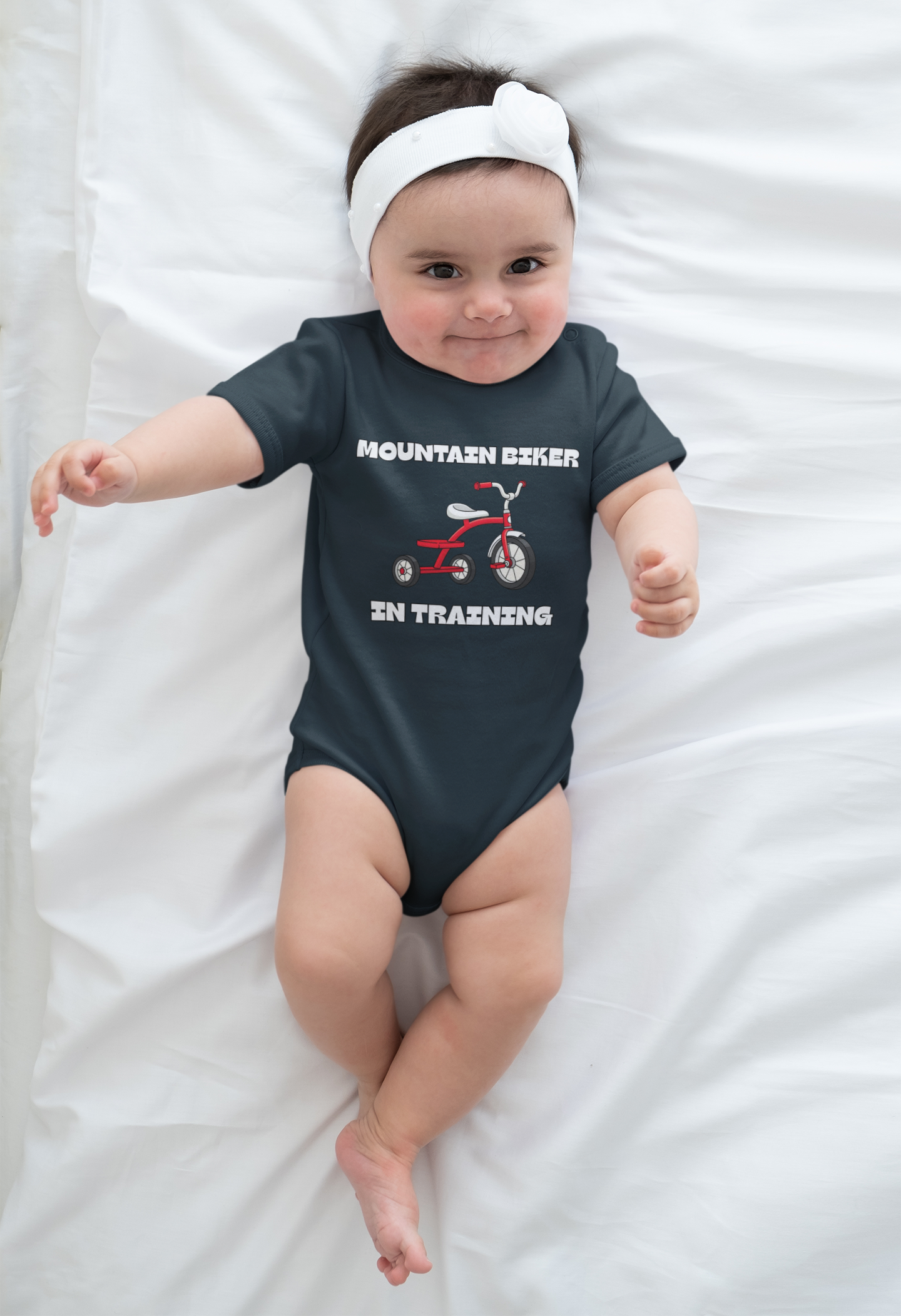 Baby girl in navy 'Mountain Biker in training' red tricycle infant tee - lying front view