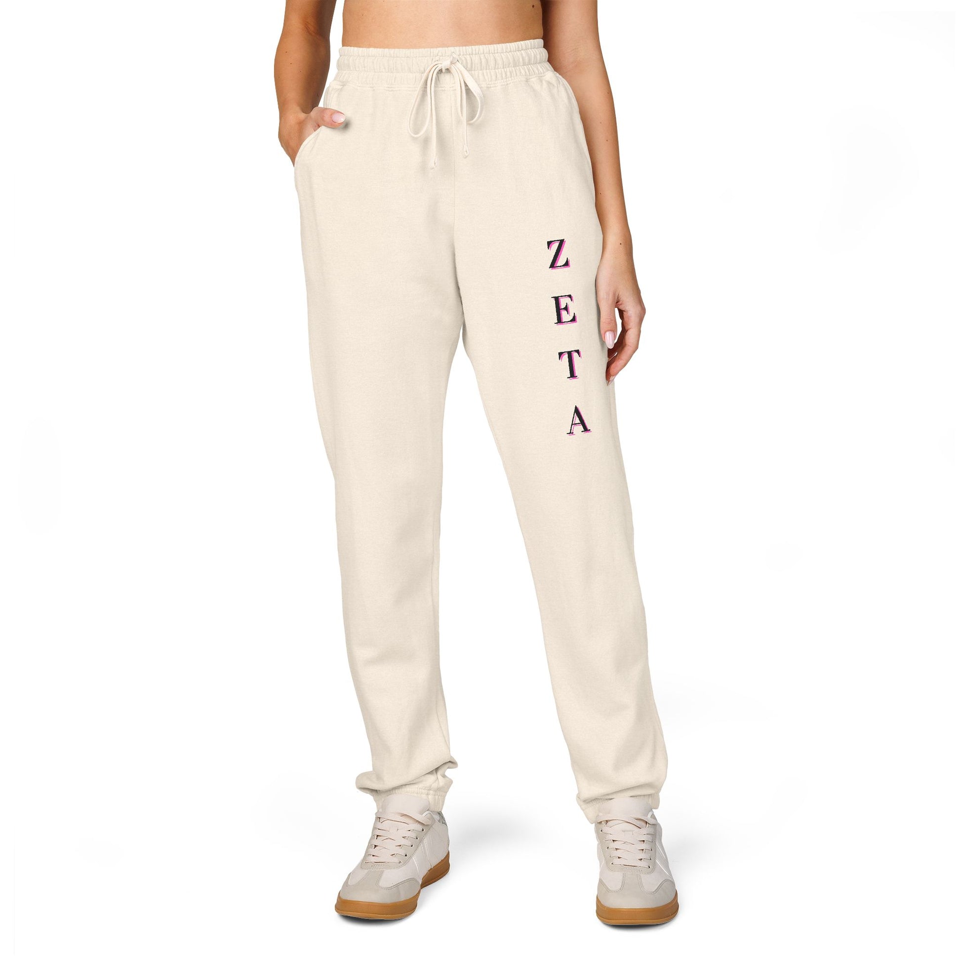 Model in off-white Zeta sweatpants showing magenta ZETA script, hands in pockets & sneakers