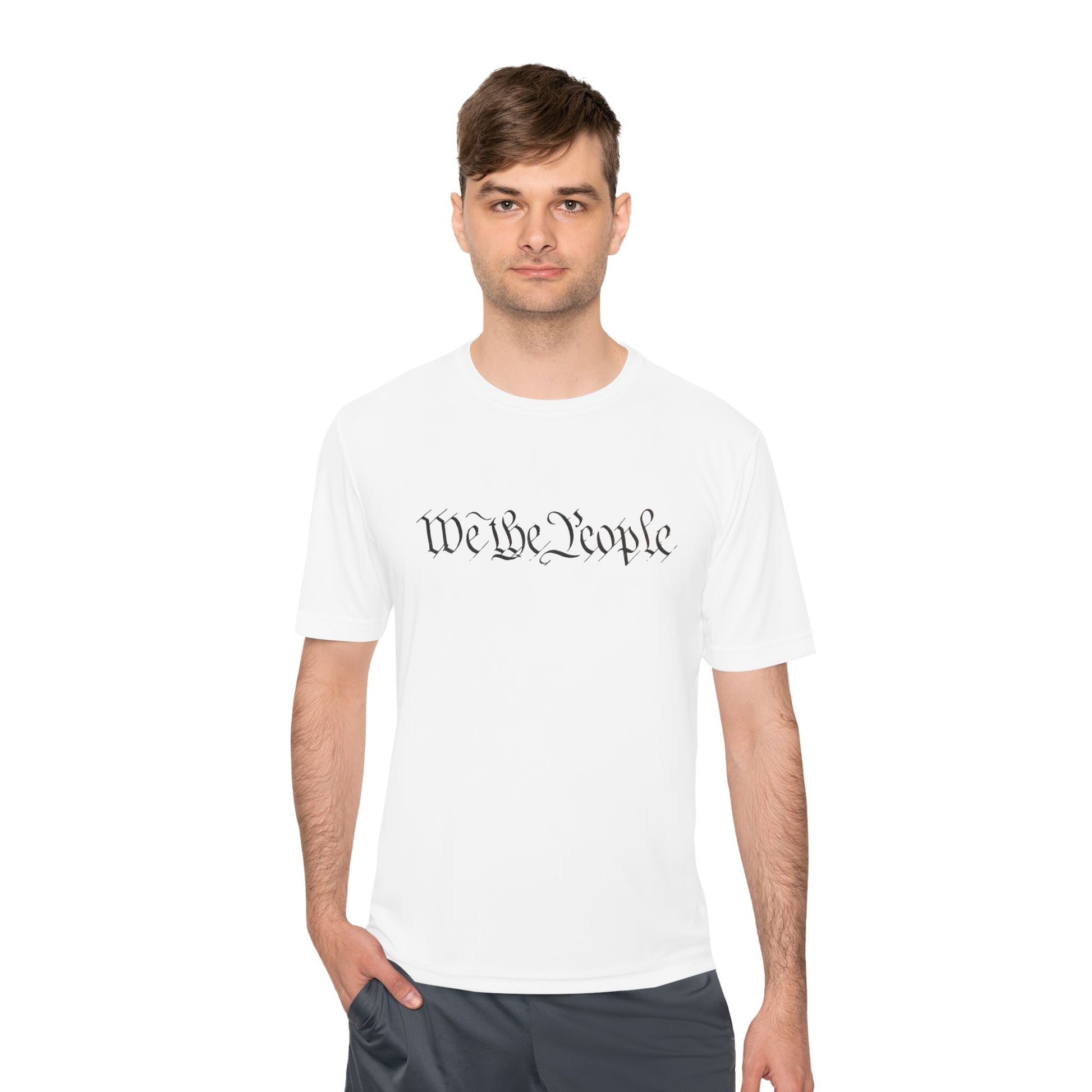 Male model in white "We the People" cursive tee, hands in pockets, patriotic smirk vibes