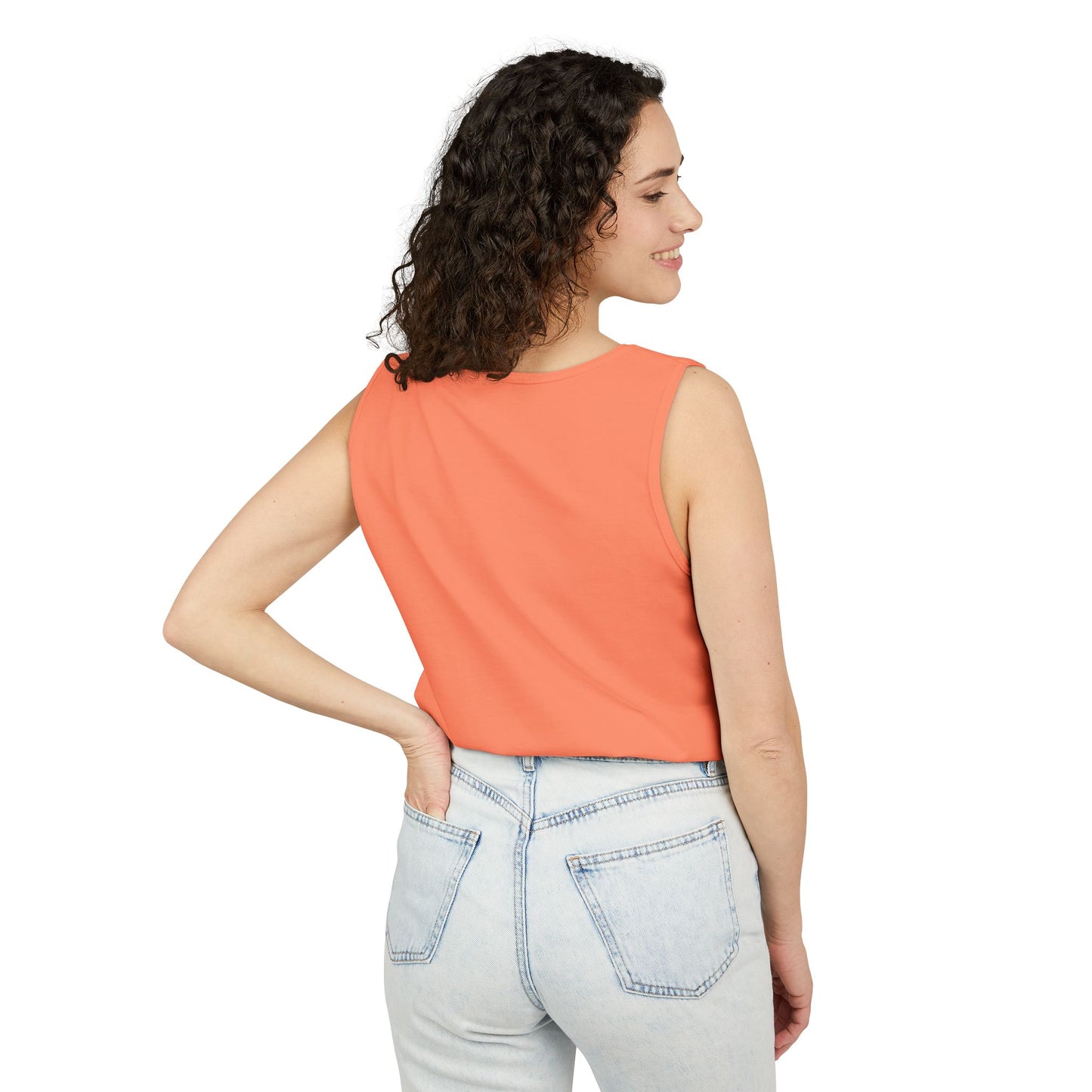 Back view of woman in plain coral tank, side hand on hip with light jeans