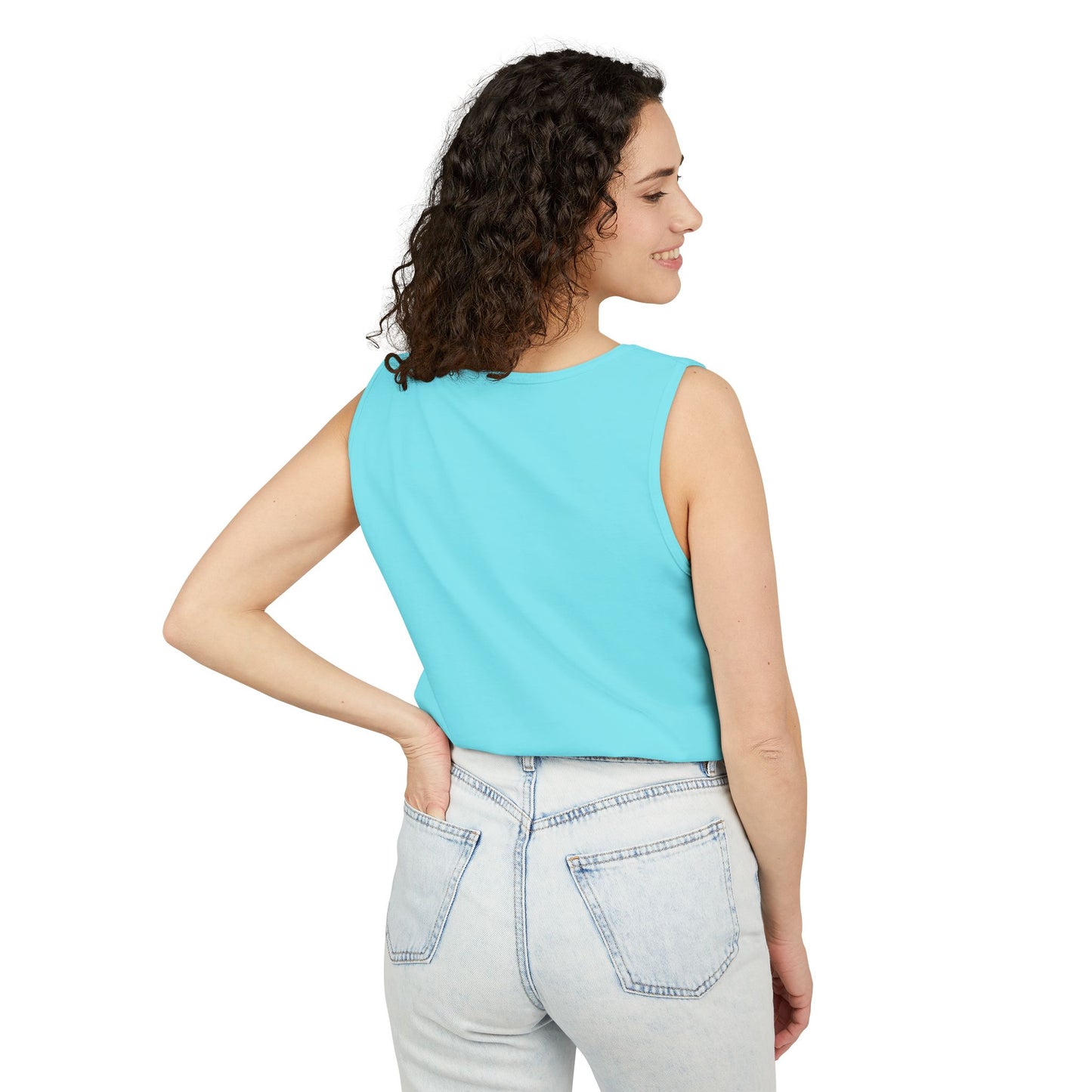Side profile of smiling woman in light cyan blue tank top, jeans and relaxed stance