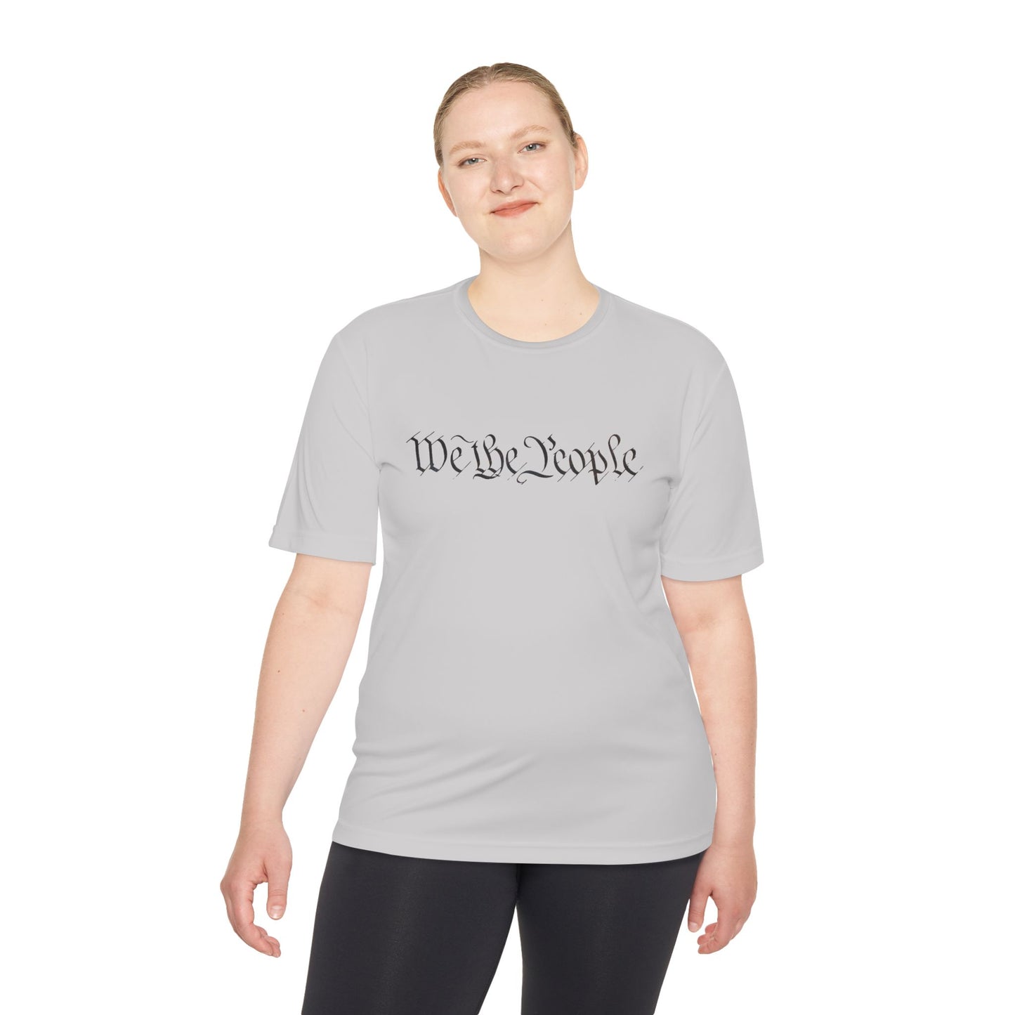 Woman in light grey moisture-wicking tee with cursive "We the People", subtle patriot flex