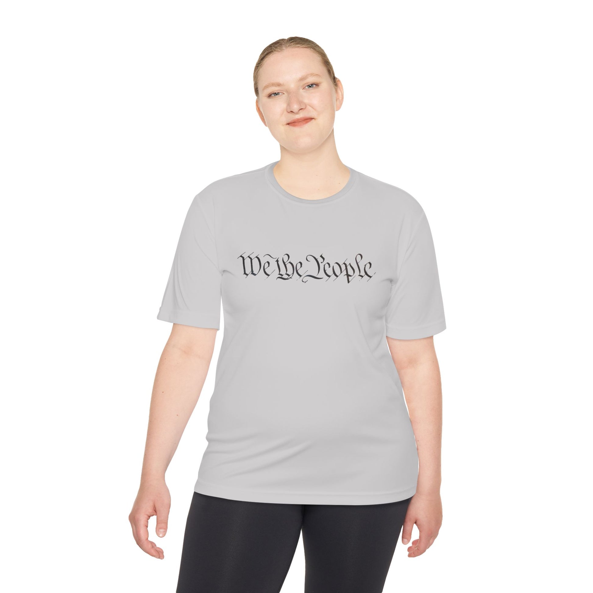 Woman in light grey moisture-wicking tee with cursive "We the People", subtle patriot flex