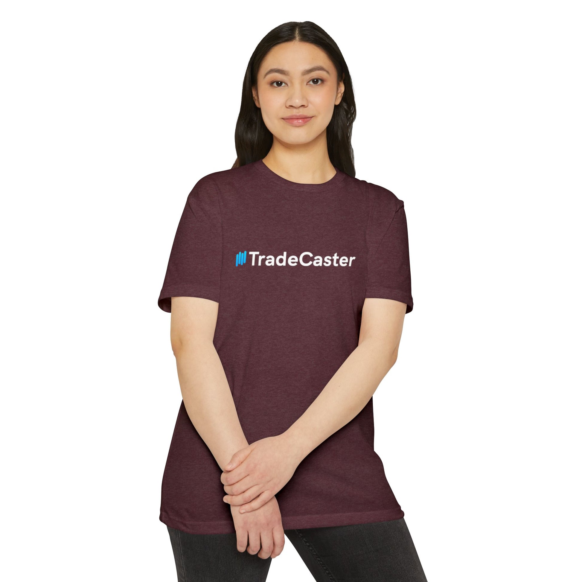 Woman front view in maroon heather TradeCaster unisex t-shirt, blue logo on chest, hands clasped playfully