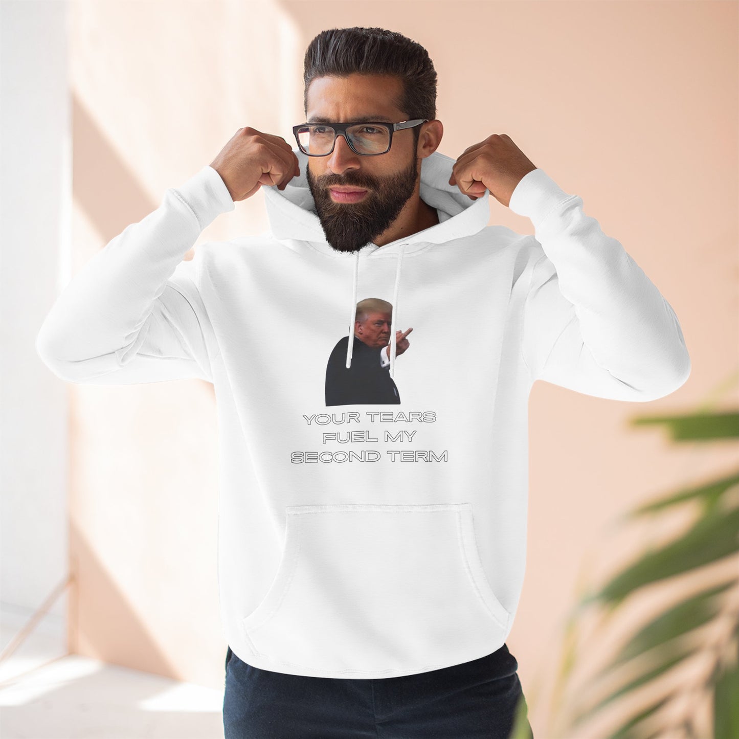 Bearded model flexing in white Trump hoodie, "YOUR TEARS FUEL MY SECOND TERM" front and center