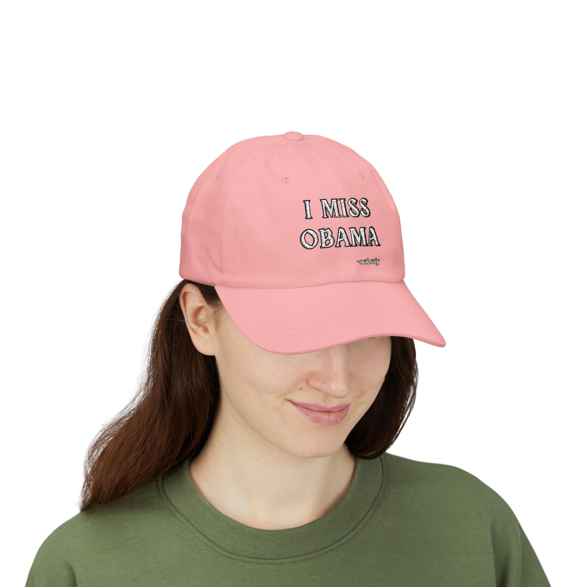 Model in green top rocking a pink dad hat with embroidered "I MISS OBAMA -nobody" front and center, sly smile 😏