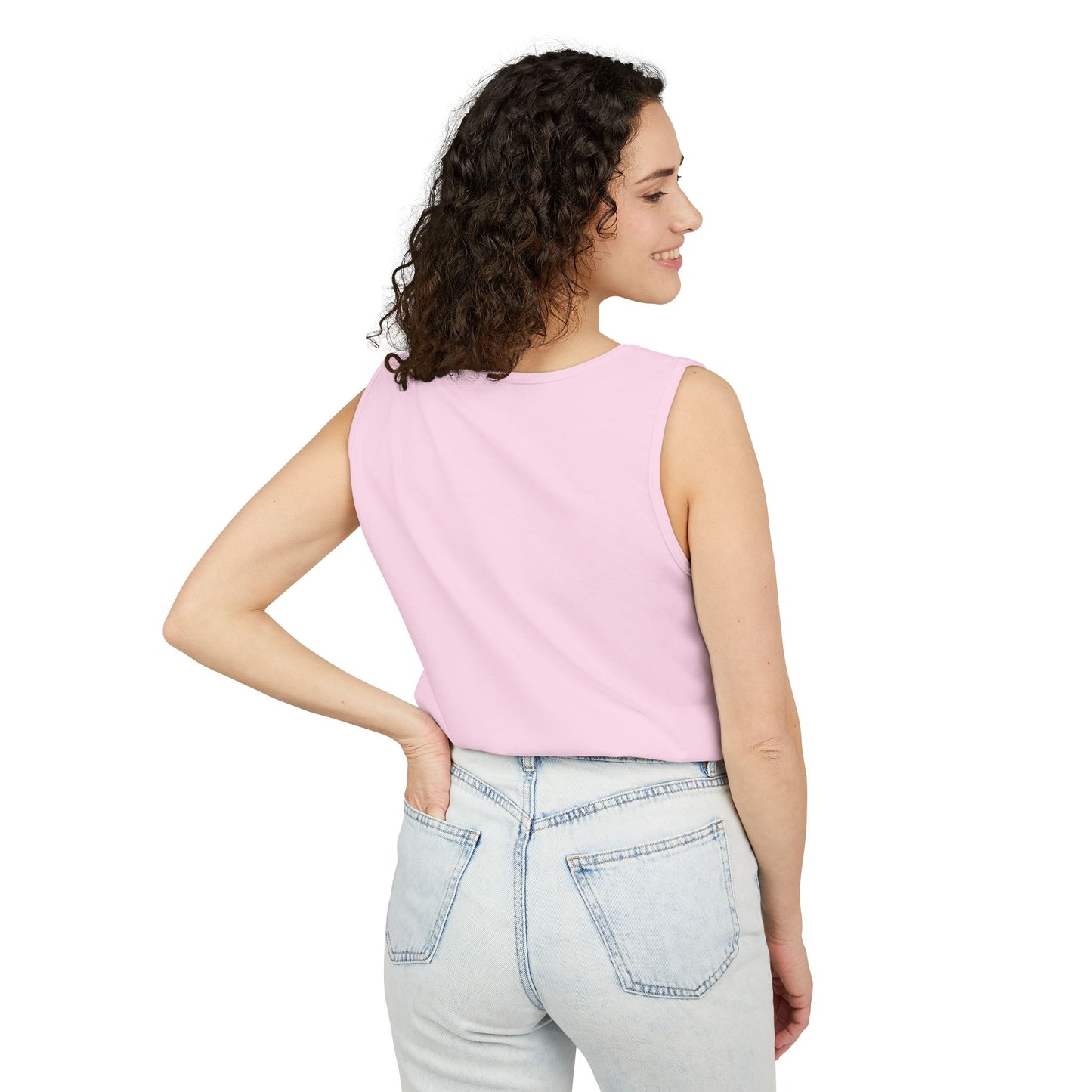 Side profile of woman in plain light pink tank top with light wash jeans