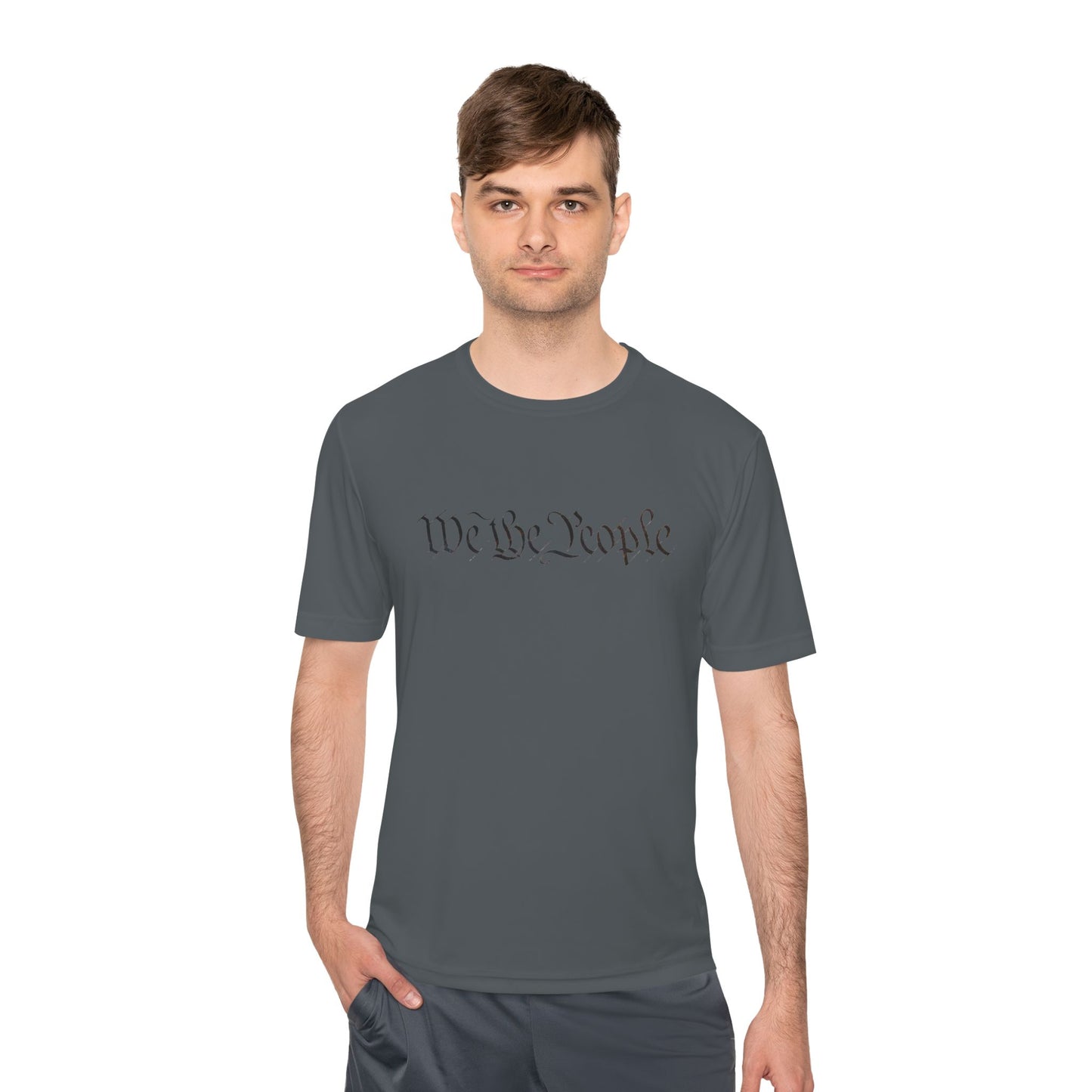 Male model in dark grey moisture-wicking tee, front view with black "We the People" script hiding QR surprise