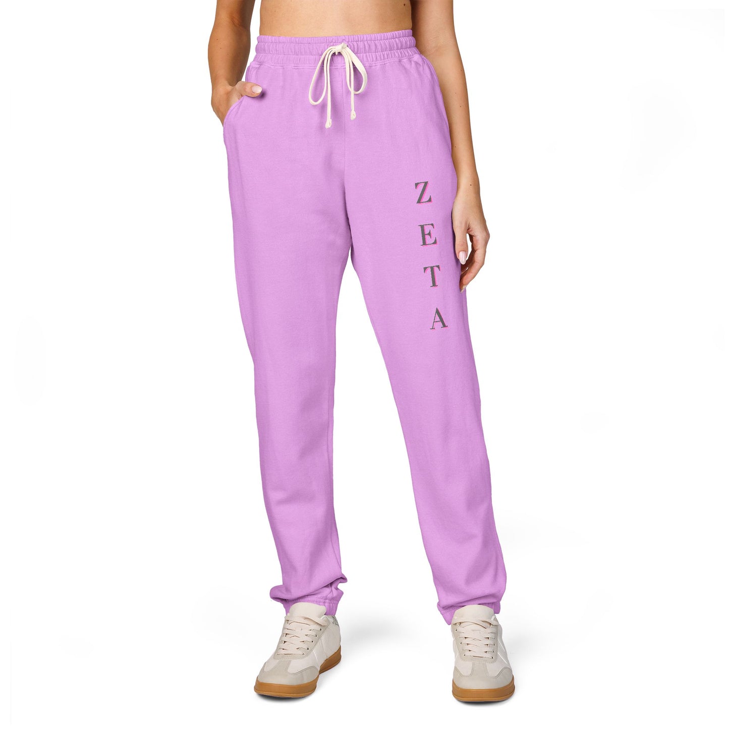 Model in front view of purple Zeta sweatpants, vertical ZETA script on leg, drawstring waist, white sneakers