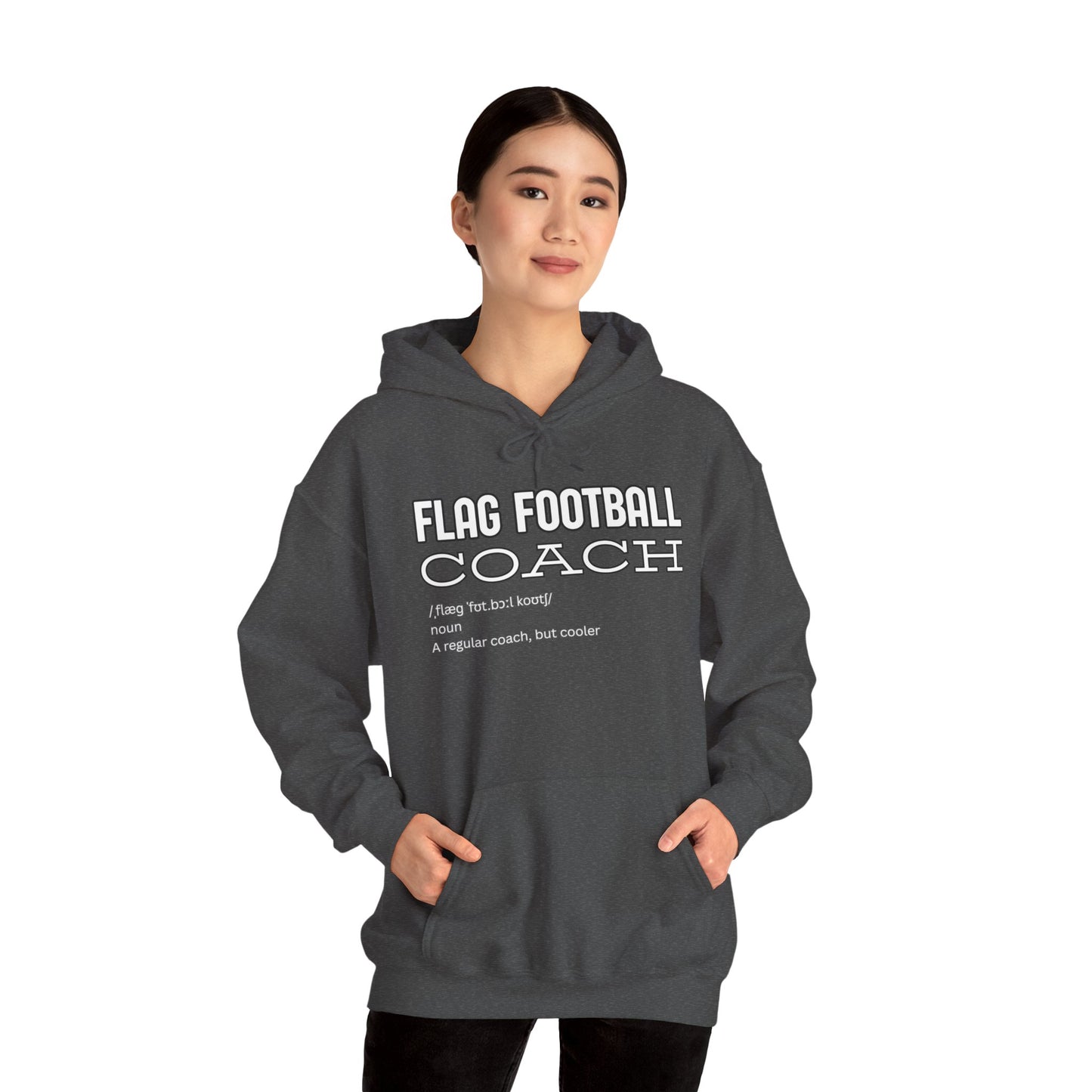 Female model in heather gray Flag Football Coach hoodie, front view with white "Like a regular coach but cooler" print, hands in pockets