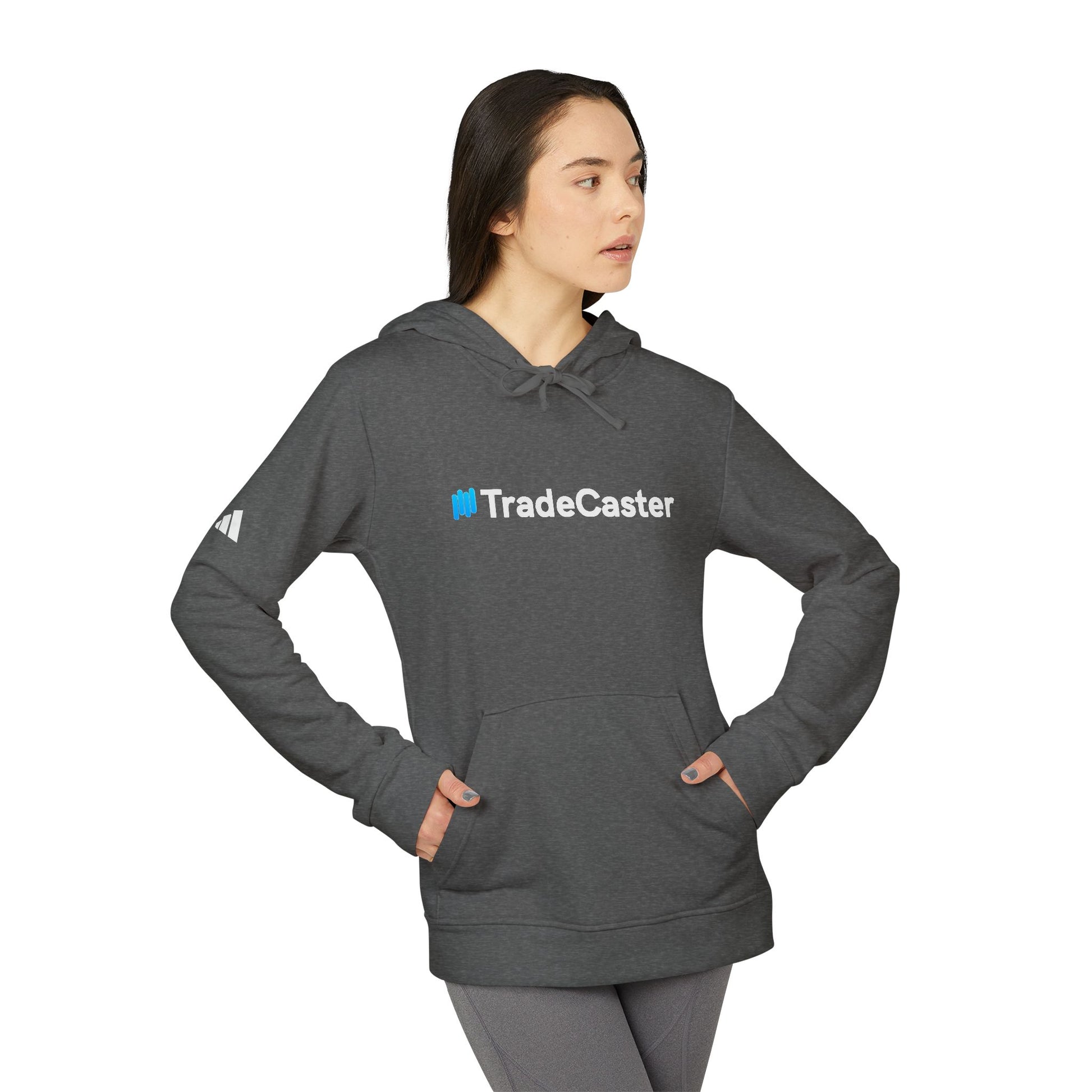 Side view of female model in grey heather TradeCaster hoodie, adidas sleeve logo peeking, poised for trade wins
