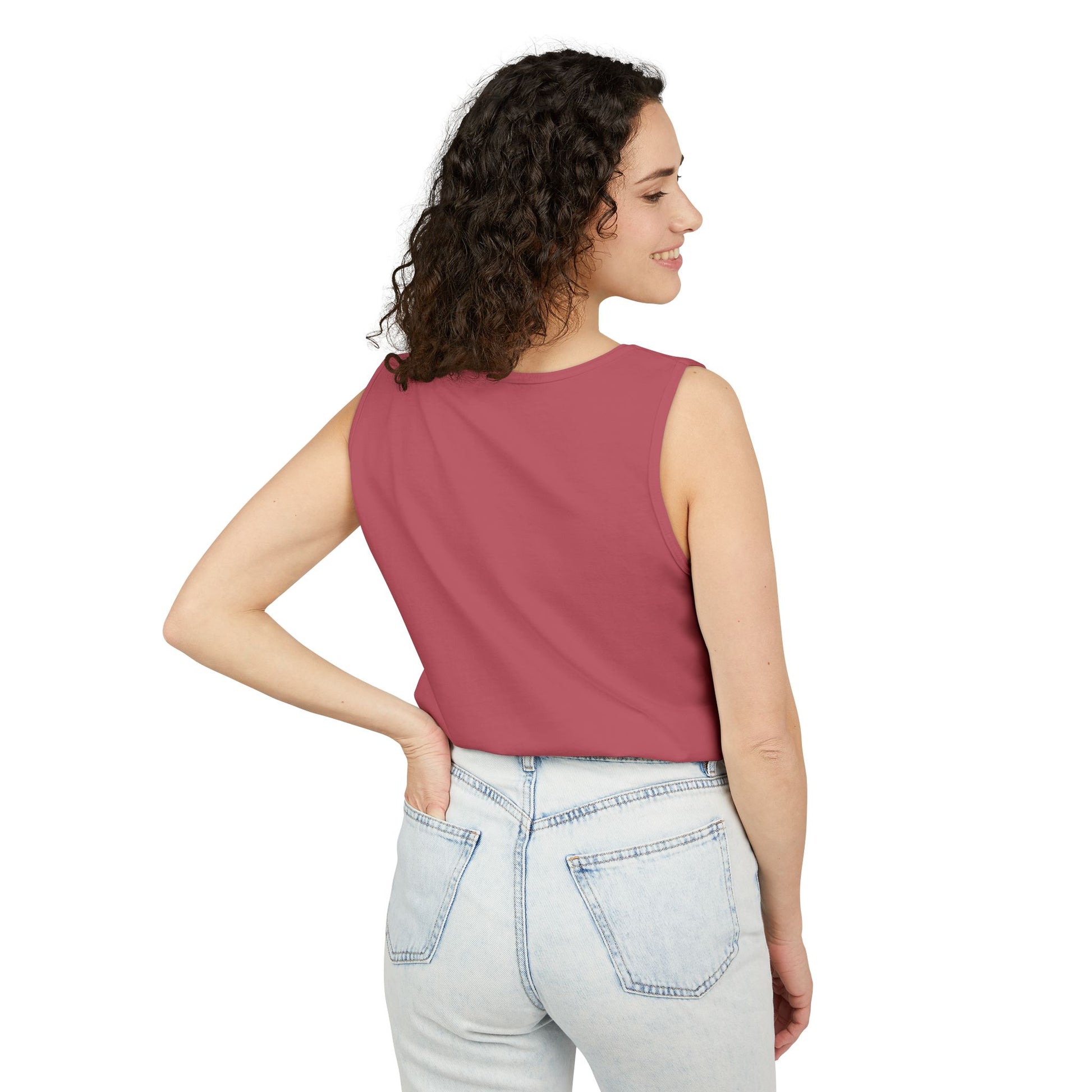 Right side view of smiling curly-haired woman in hot pink tank top and light wash jeans