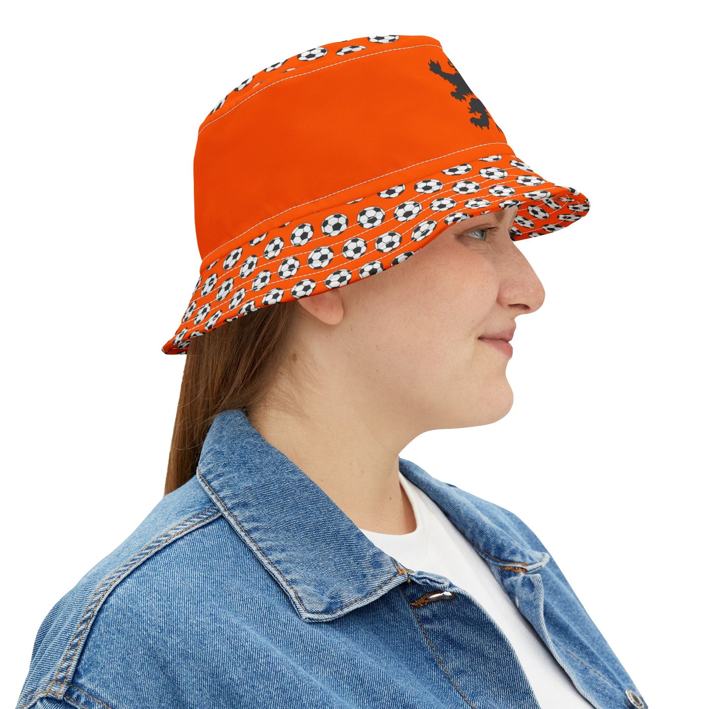 Woman side profile in orange lion bucket hat, soccer print brim & hint of black lion emblem