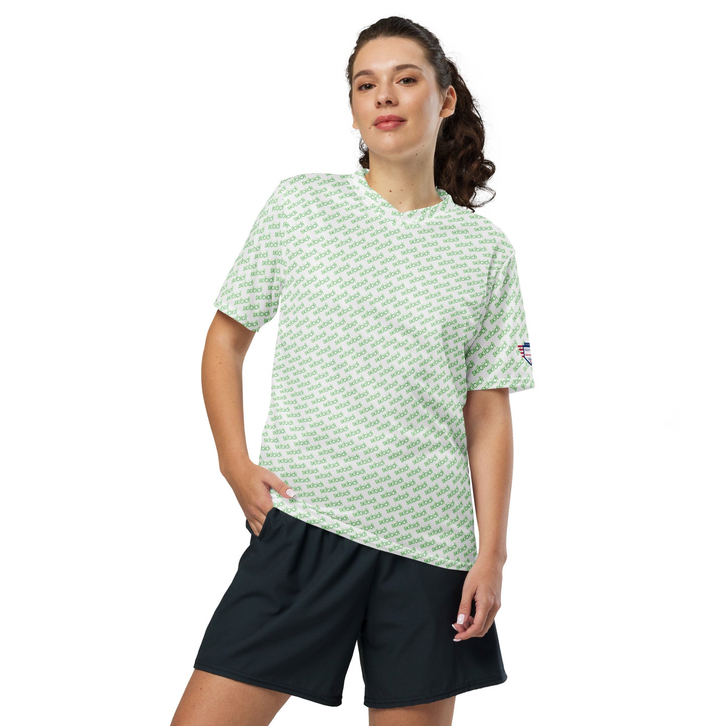 Female model in ponytail posing front-on with white green "skibidi" all-over sports jersey, black shorts