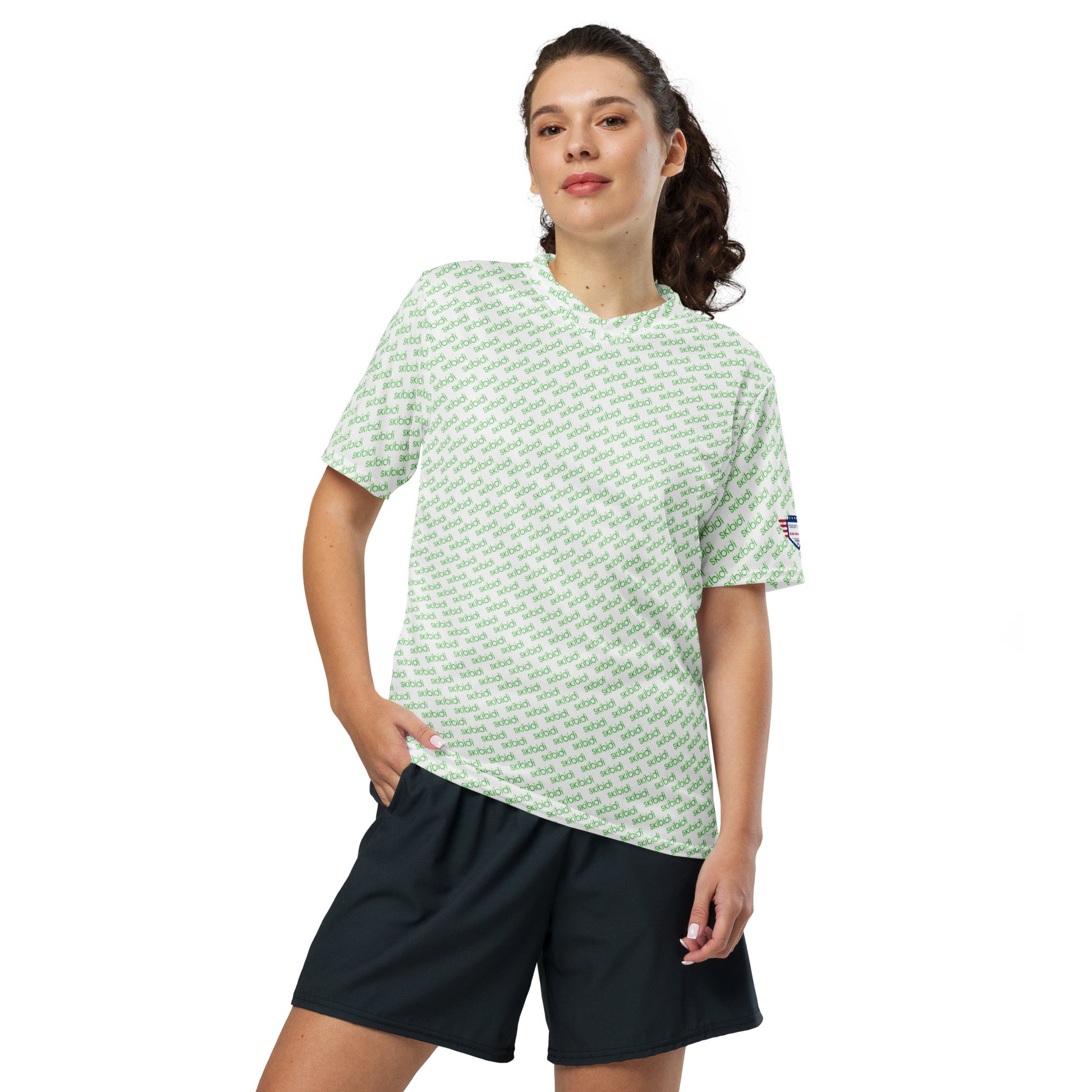 Female model in ponytail posing front-on with white green "skibidi" all-over sports jersey, black shorts