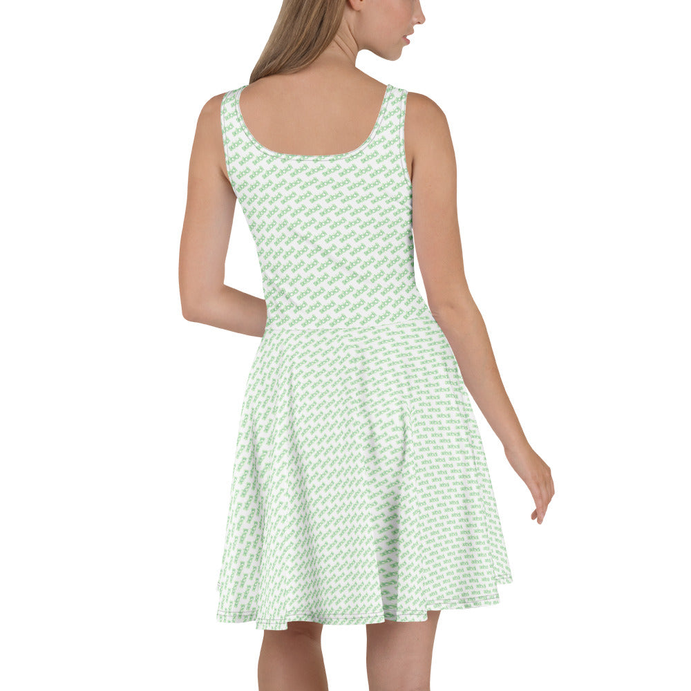 Back view of blonde model in mint green skibidi skater dress, seamless all-over white toilet-head pattern